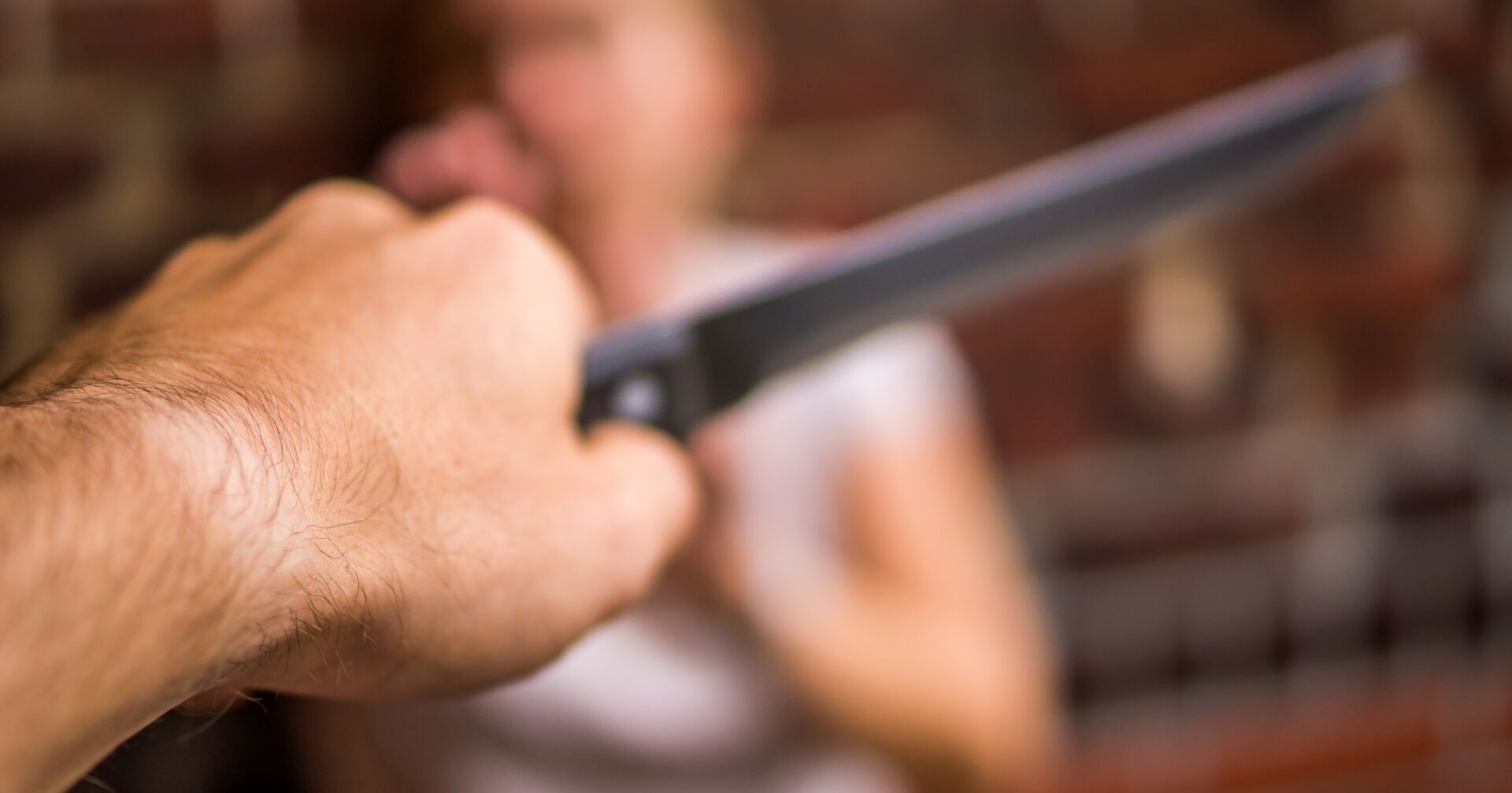 Ein Mann greift eine Frau mit einem Messer an.