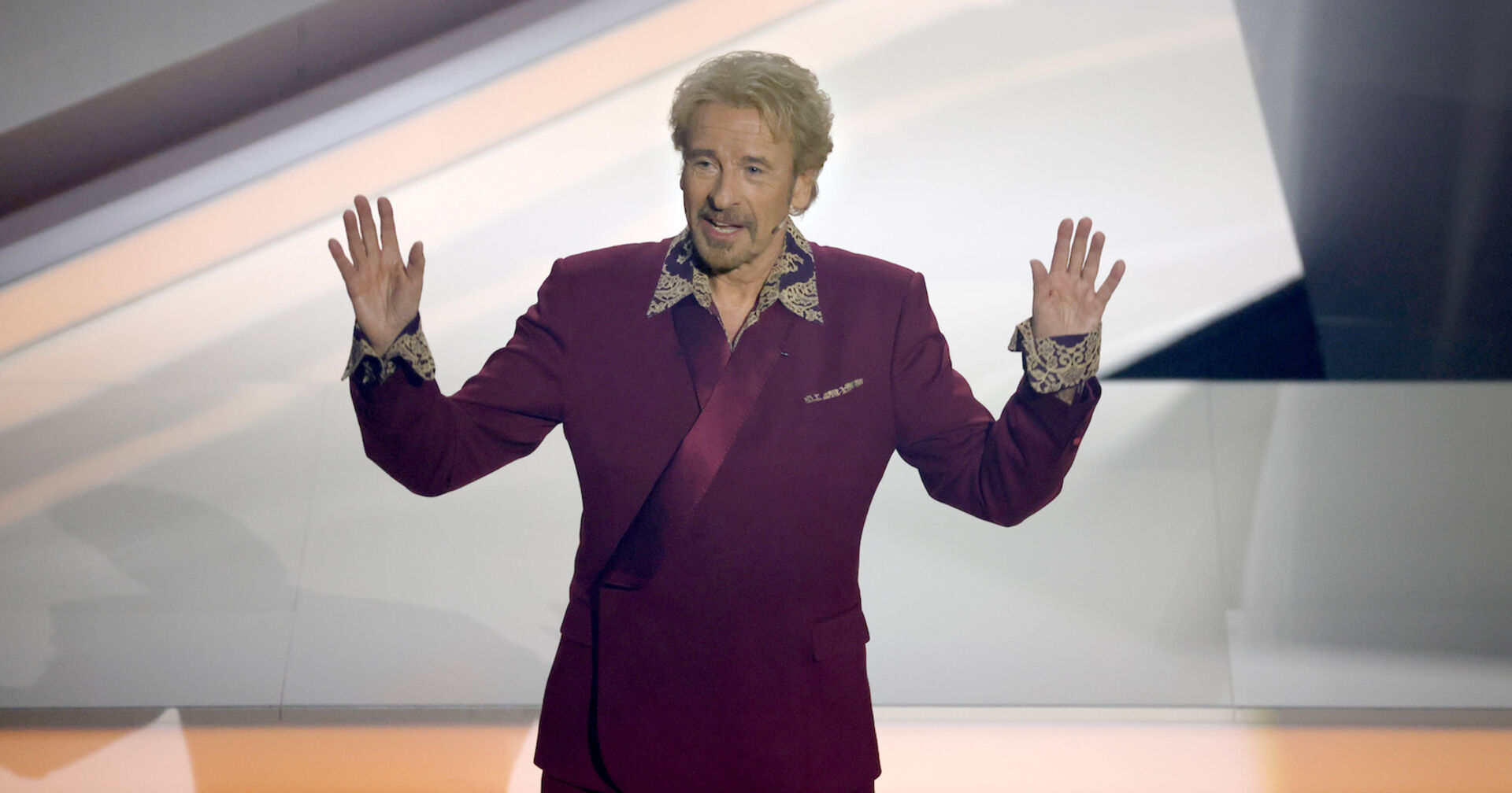 Thomas Gottschalk trägt einen dunkelroten Anzug.