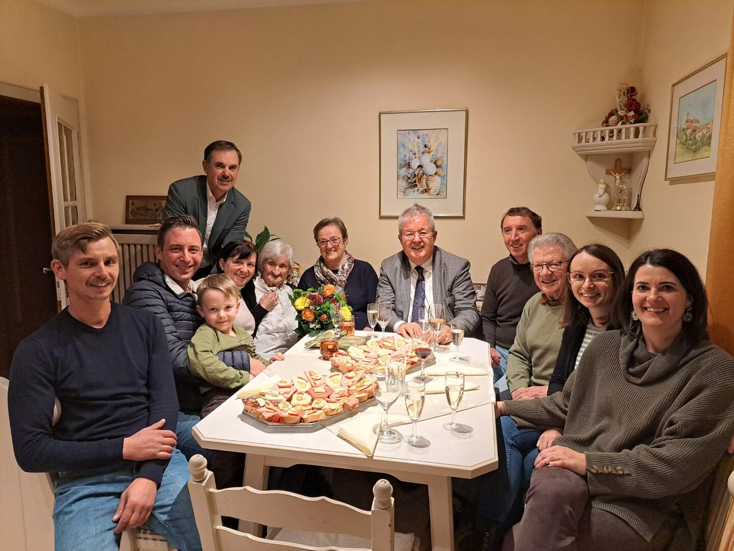 Menschen sitzen um den Tisch, um Geburtstag zu feiern