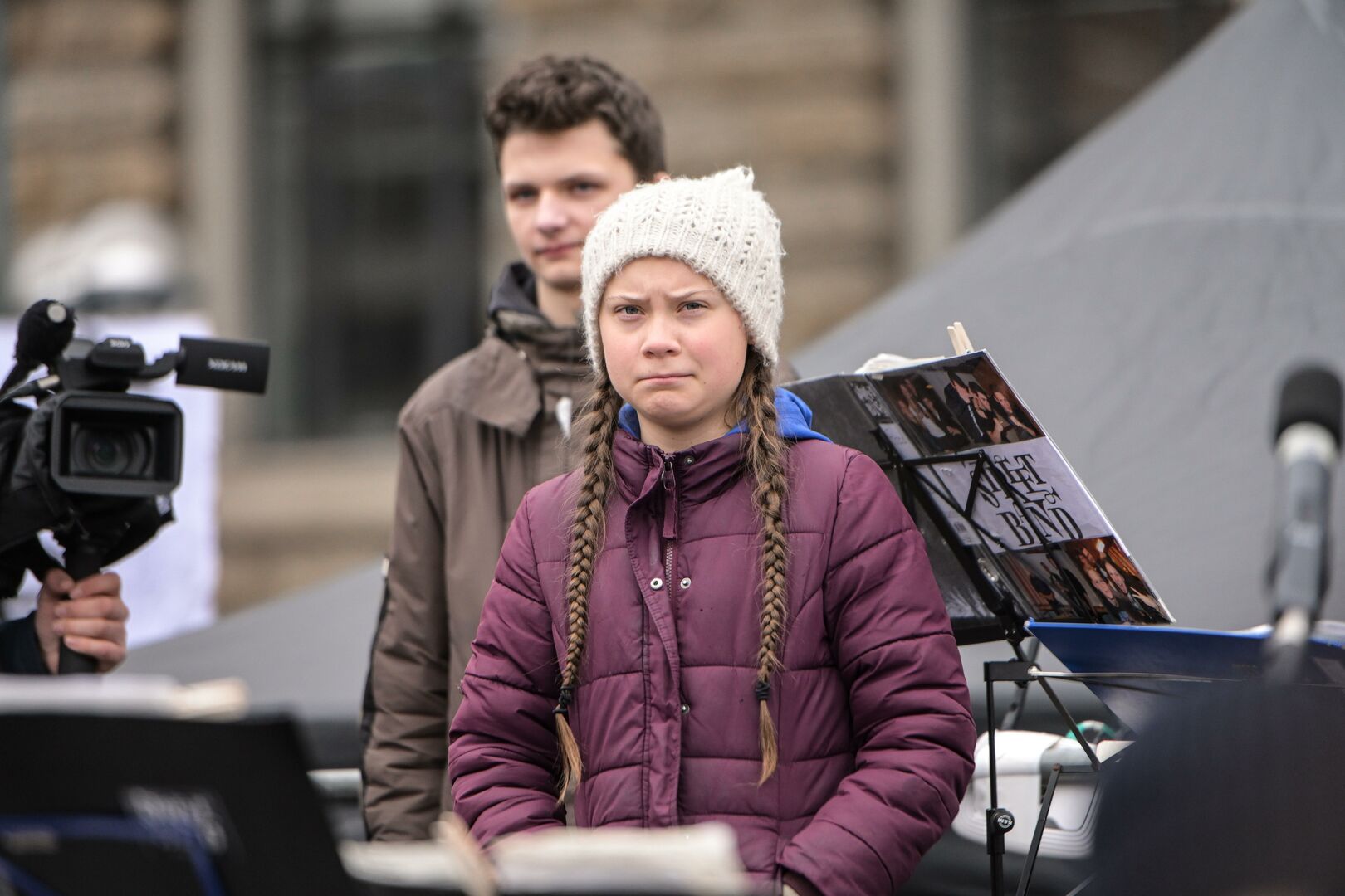 Greta Thunberg, die von einem Rednerpult aus auf ihr Publikum blickt