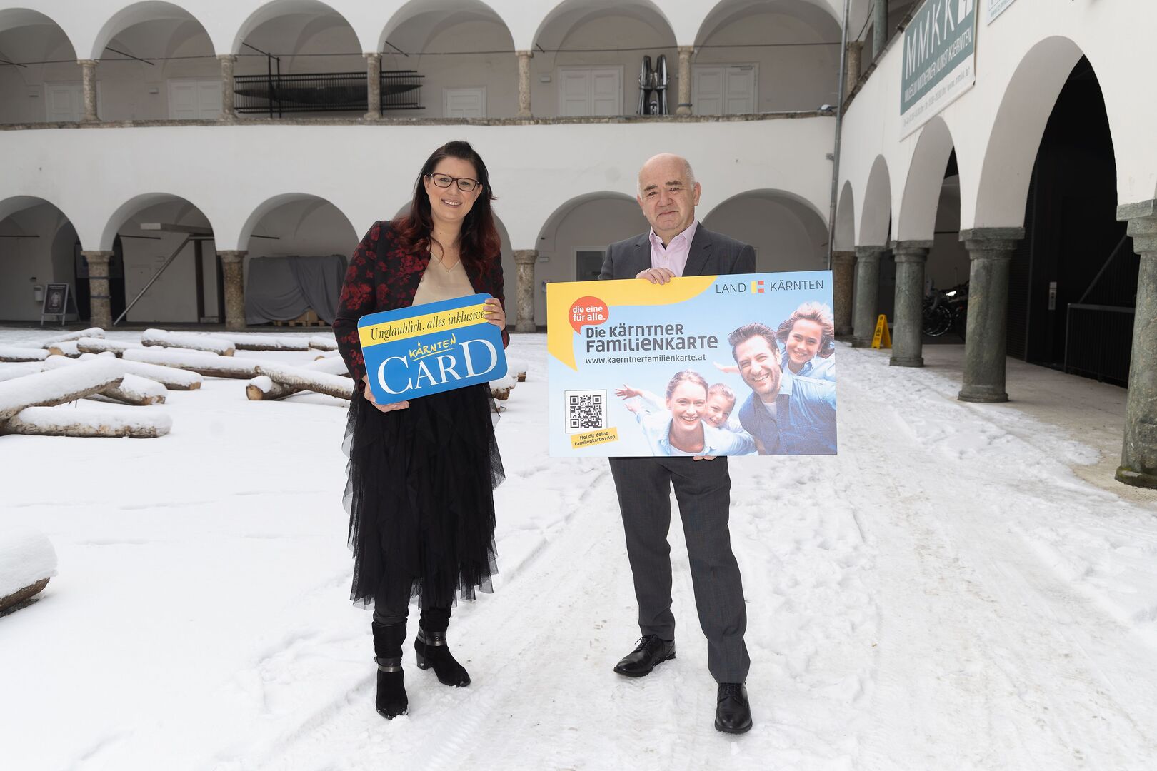 Sara Schaar und Manfred Hautz im Burghof Klagenfurt mit Karten in den Händen