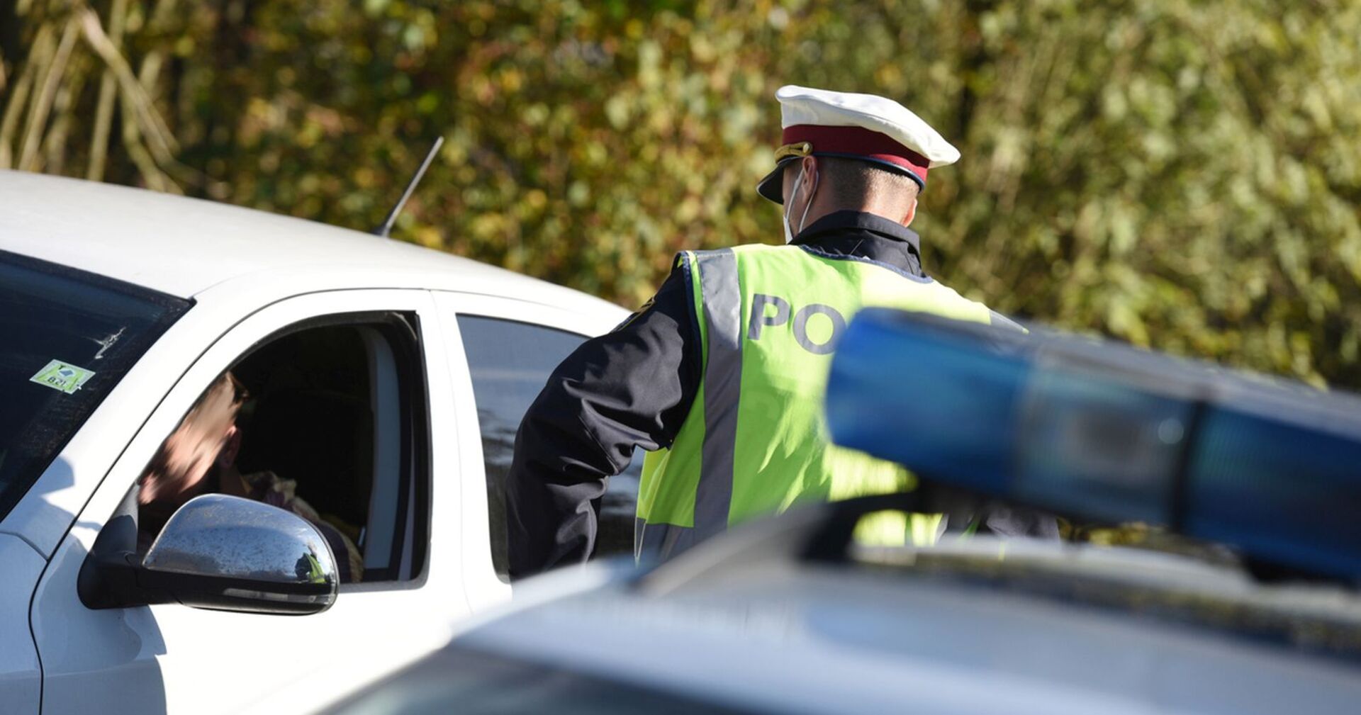 Ein Polizist kontrolliert einen Autofahrer.