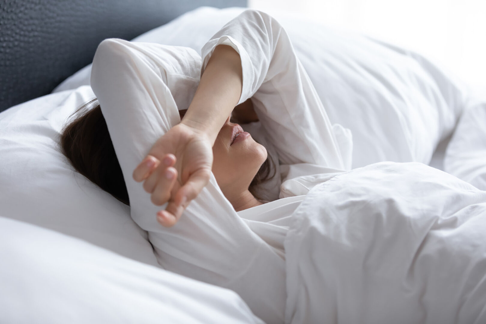 Frau liegt im Bett | Credit: iStock.com/fizkes
