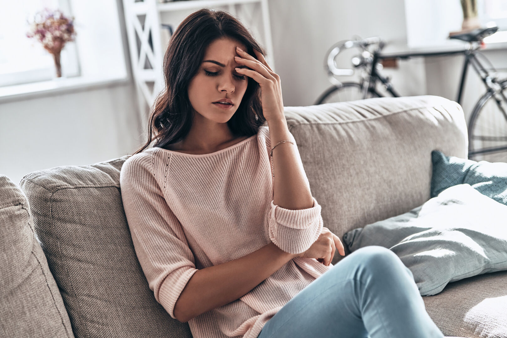 Frau sitzt frustriert auf der Couch | Credit: iStock.com/g-stockstudio