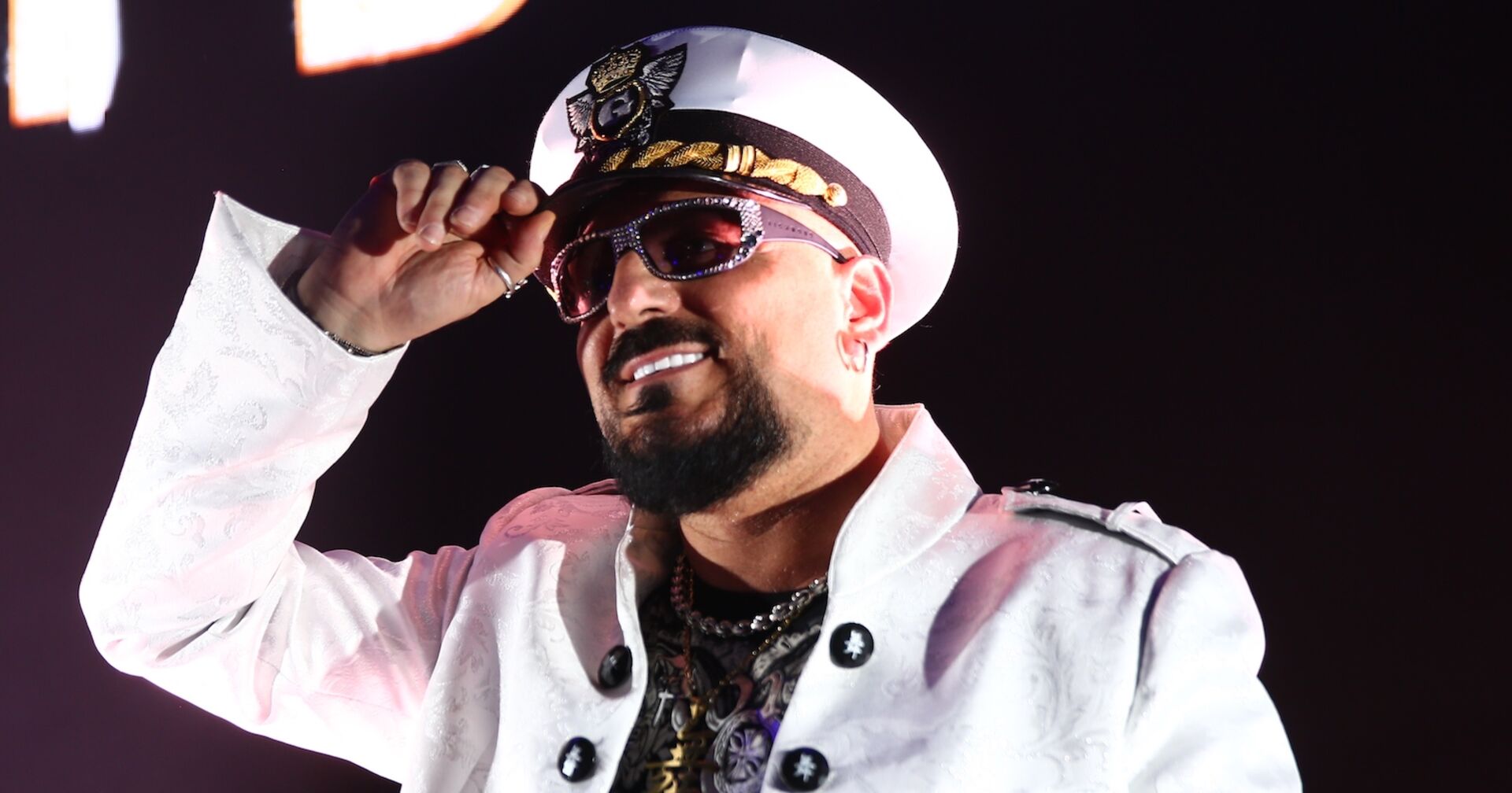 Gigi D'Agostino mit einem weißen Hut und einem weißen Sakko.