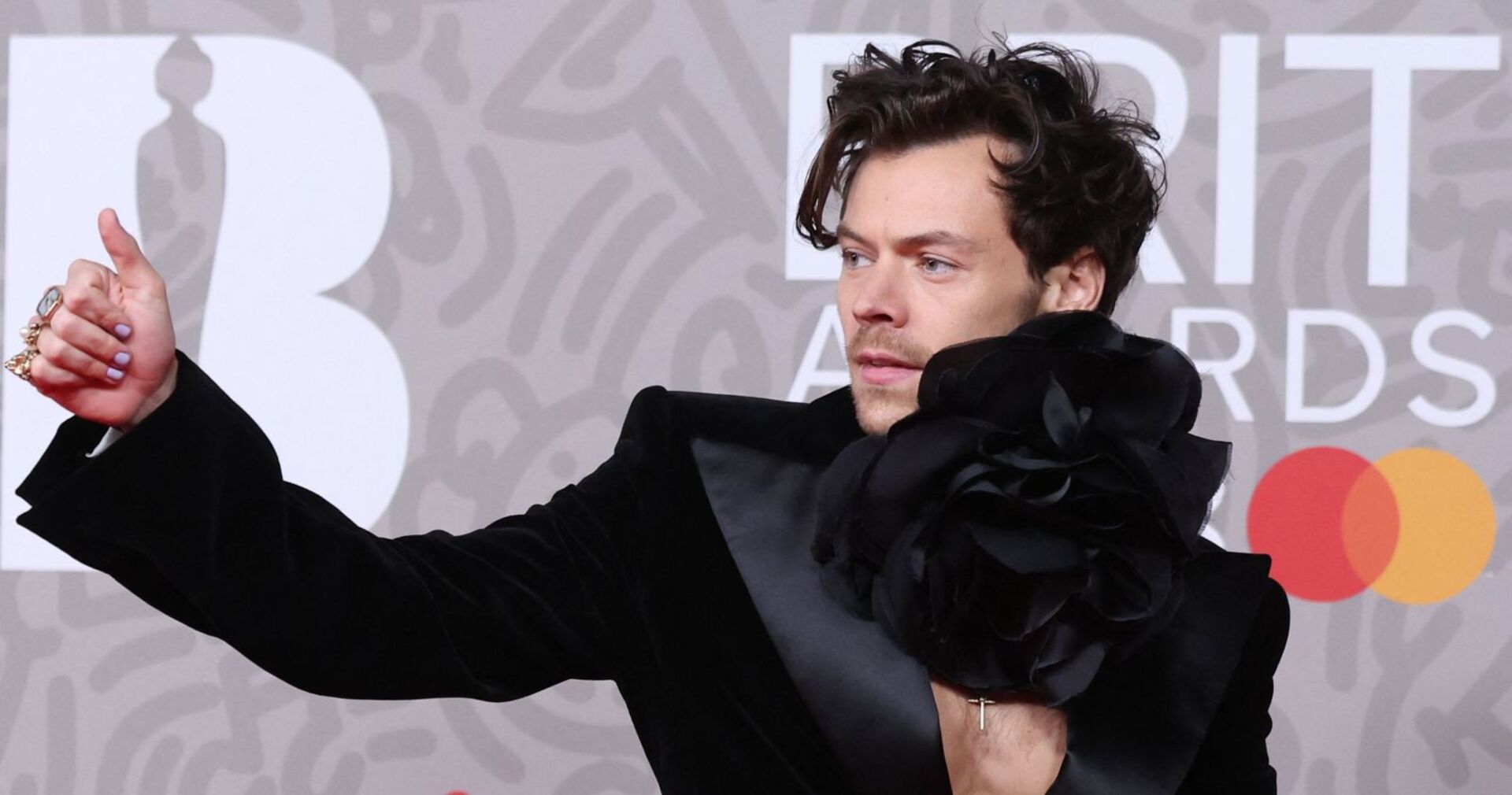 Harry Styles zeigt auf einem Event "Daumen hoch".