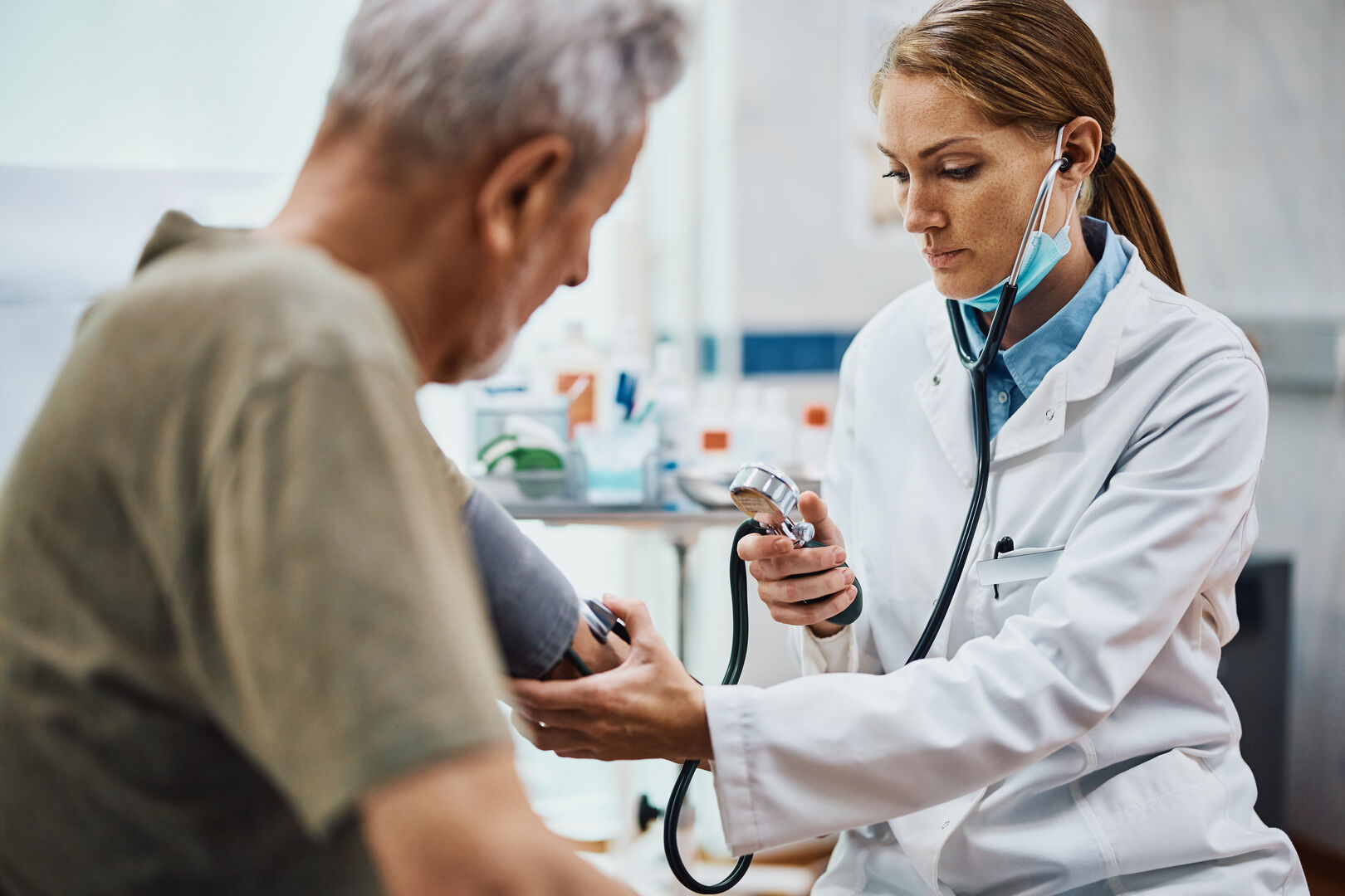 Eine Ärztin misst in ihrer Praxis den Blutdruck eines älteren Patienten