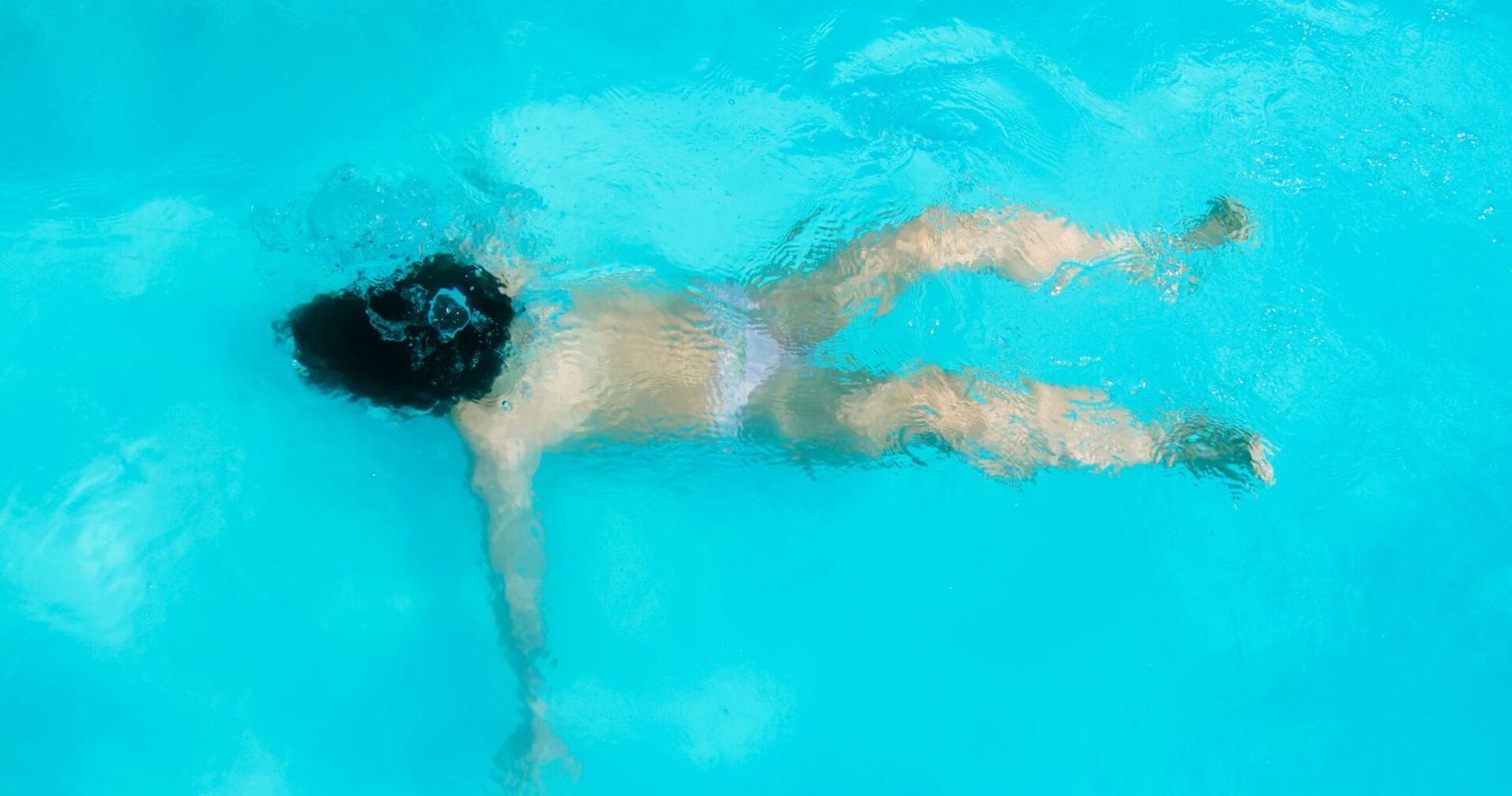 Ein Kind treibt reglos im Wasser.