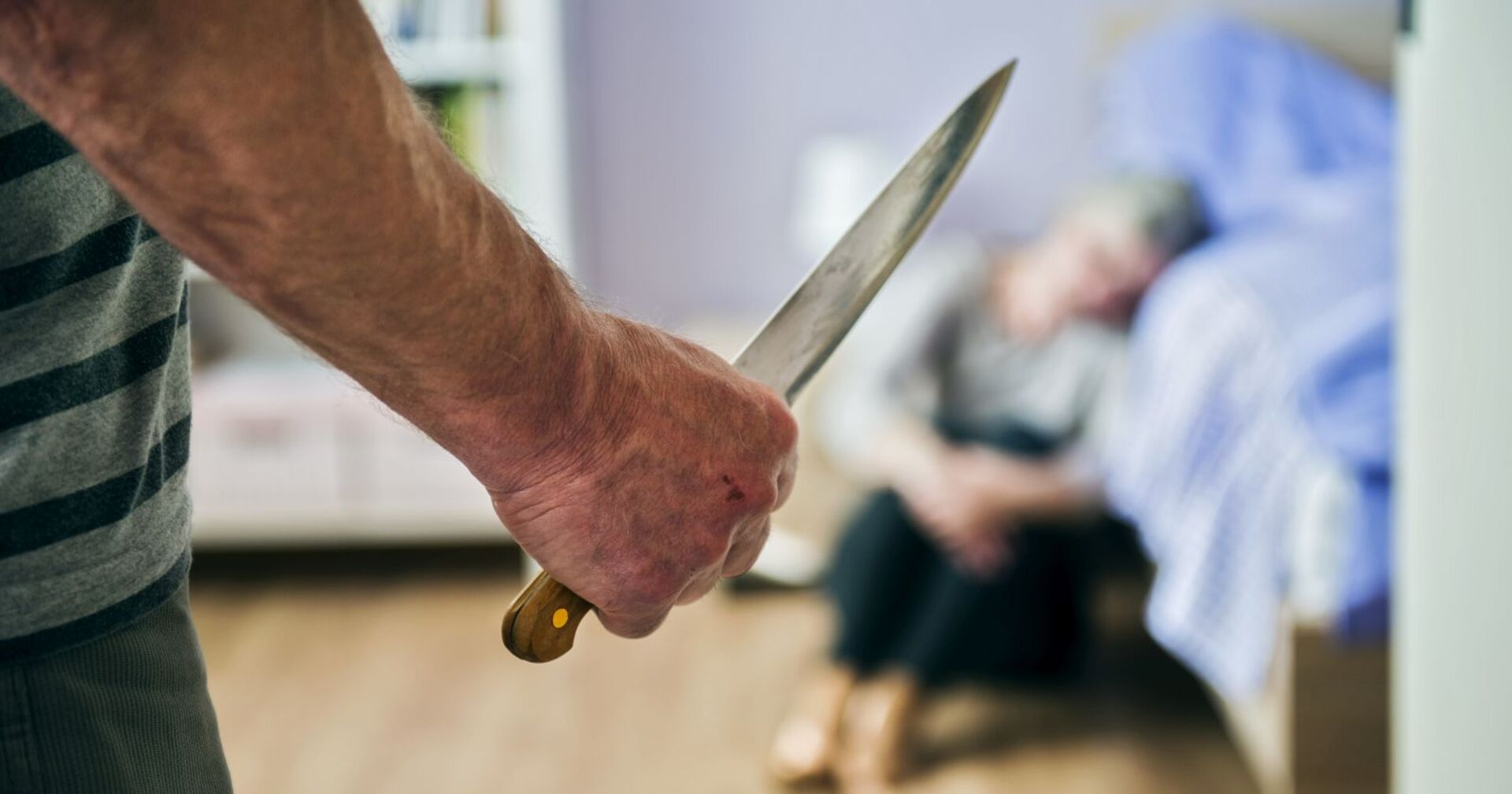 Ein Mann bedroht eine Frau mit einem Küchenmesser