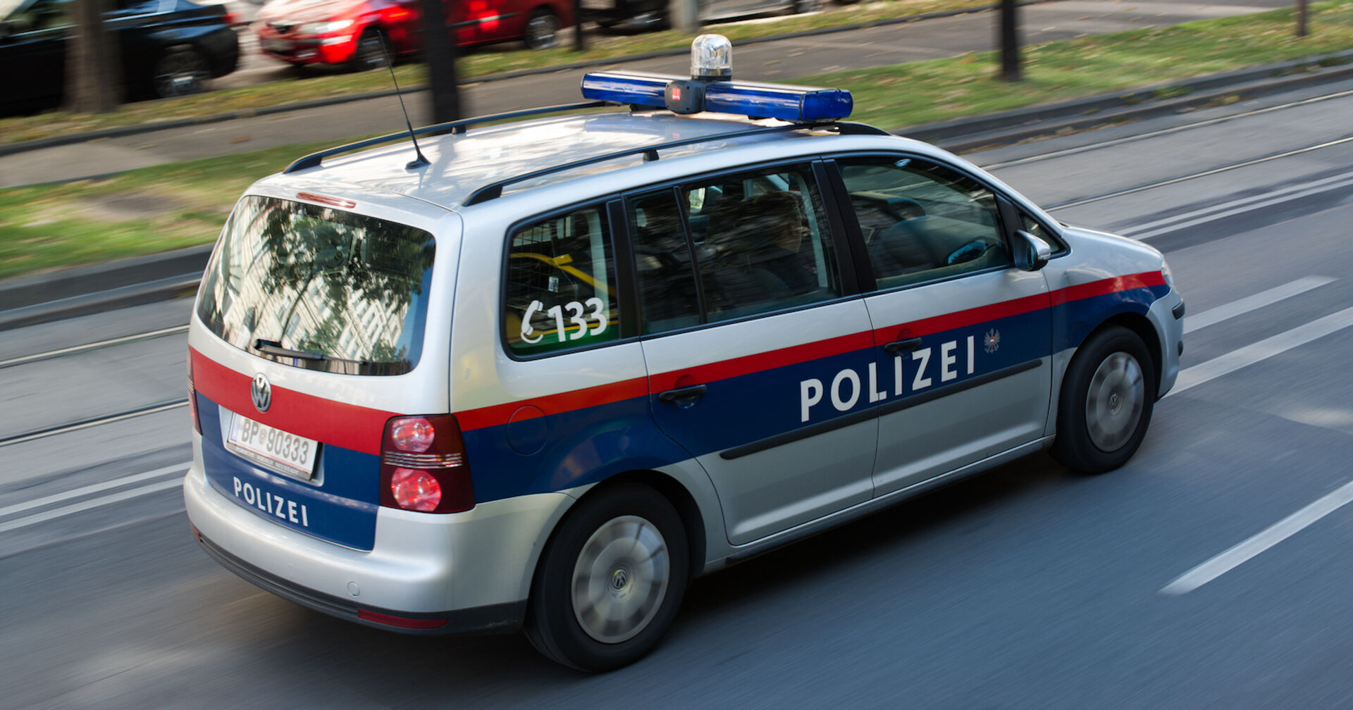 Ein Polizeiauto fährt auf einer Wiener Straße.