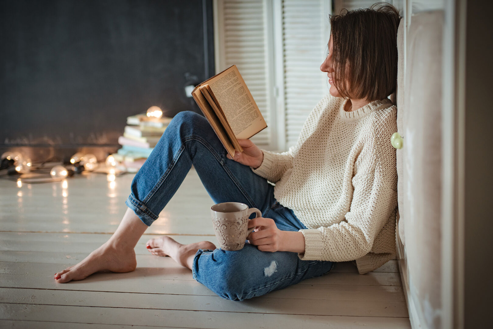Frau sitzt am Boden und liest | Credit: iStock.com/Shangarey