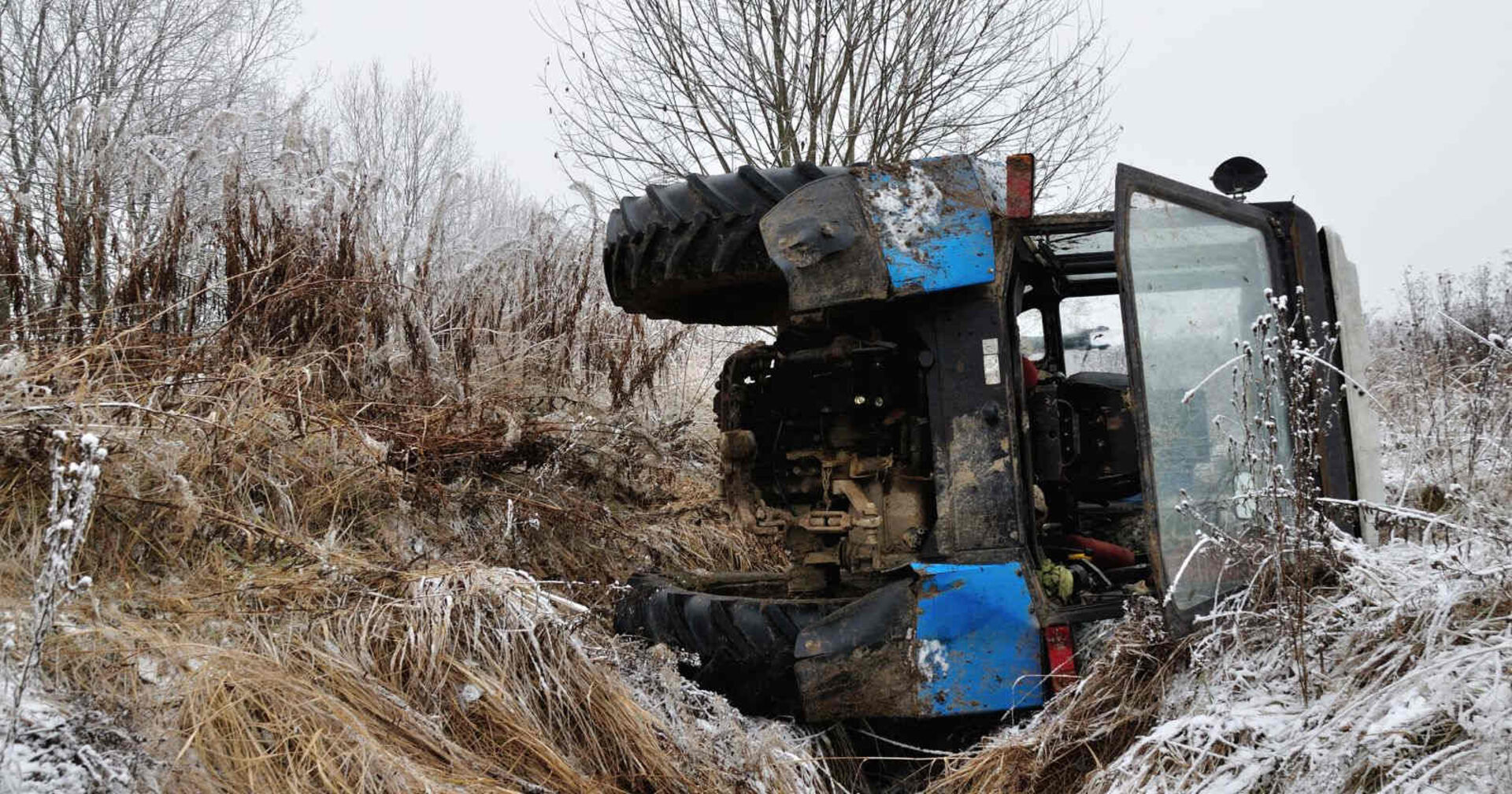 Ein Traktor liegt auf der Seite in einem Graben.