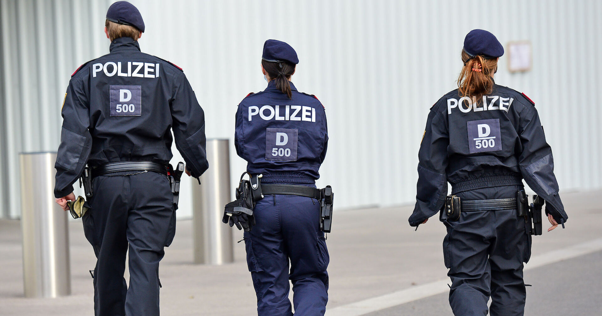 Drei Polizisten in Uniform von hinten