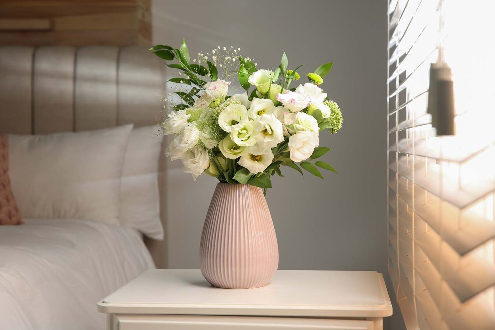 Blumenvase auf einem Nachttisch | Credit: iStock.com/Liudmila Chernetska