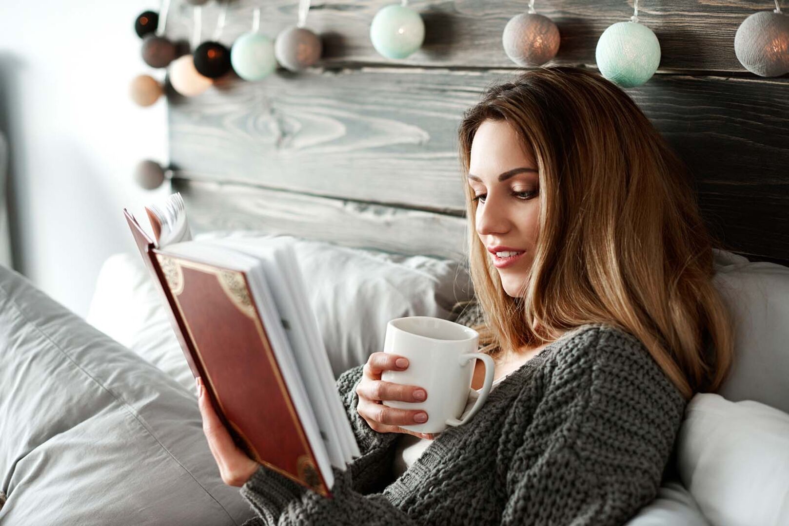 Frau liest Buch im Bett | Credit: iStock.com/gpointstudio
