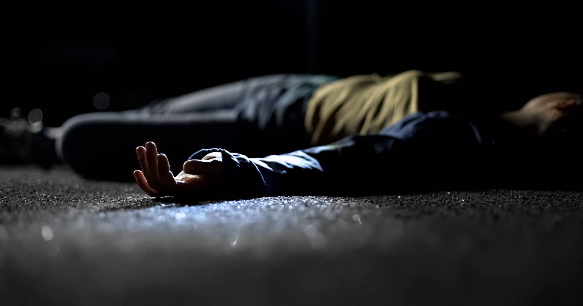 Eine Frauenleiche, die im Dunkeln auf einer Straße liegt