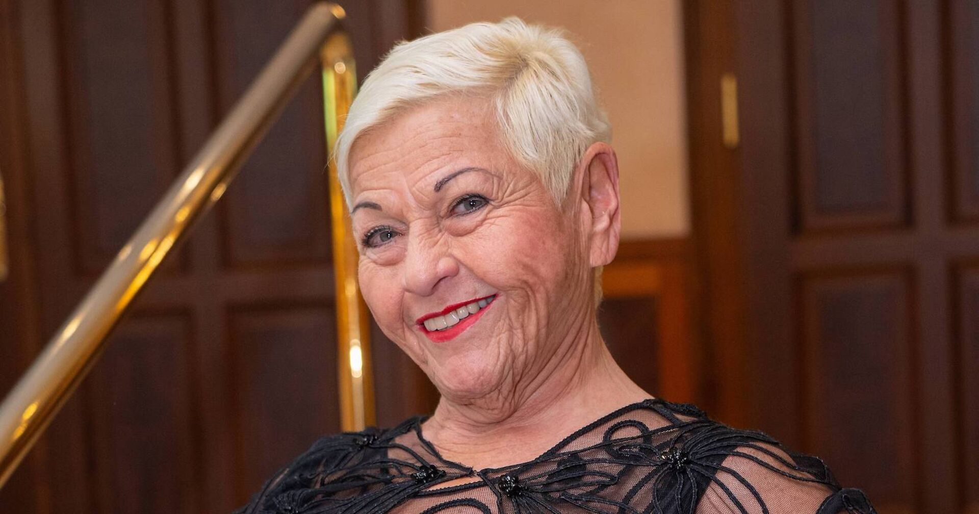 Jazz Gitti mit kurzen blonden Haaren und einem schwarzen Kleid.