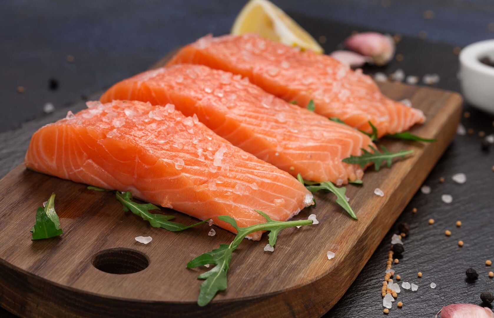 Lachsfilet auf einem Holzbrett | Credit: iStock.com/Metkalova