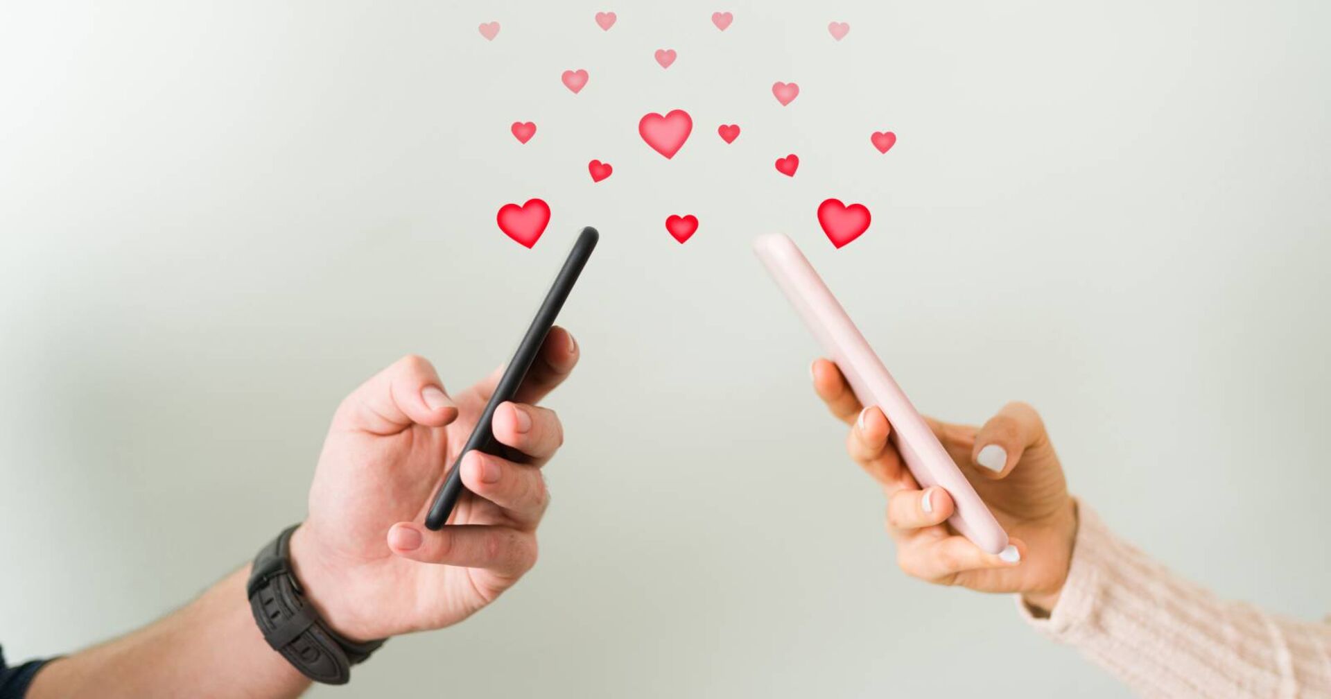 Zwei Personen mit Smartphones, die sich gegenseitig mit Hilfe von Nachrichten Herzenchen schicken