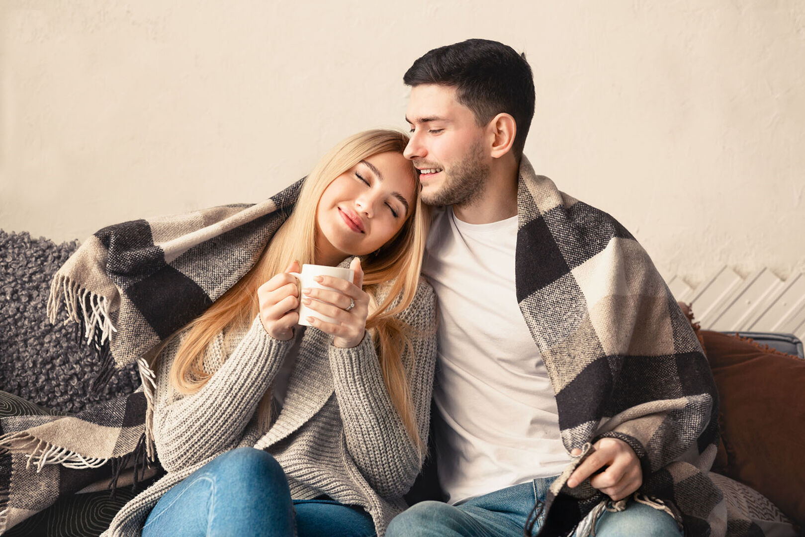 Paar kuschelt auf der Couch | Credit: iStock.com/Prostock-Studio
