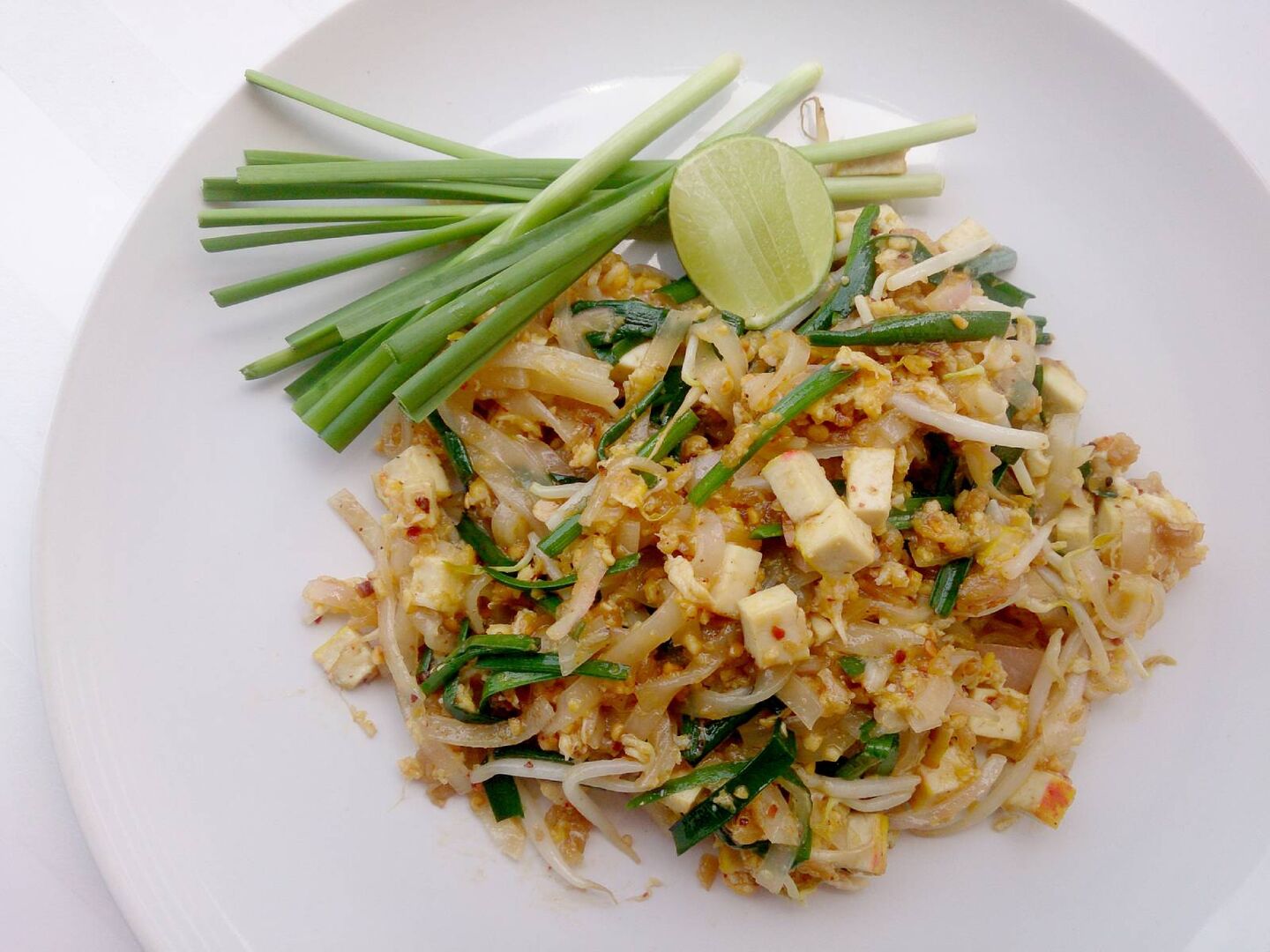 Teller mit gebratenen Reisnudeln, Frühlingszwiebeln und Tofu, auch bekannt als "Pad Thai".