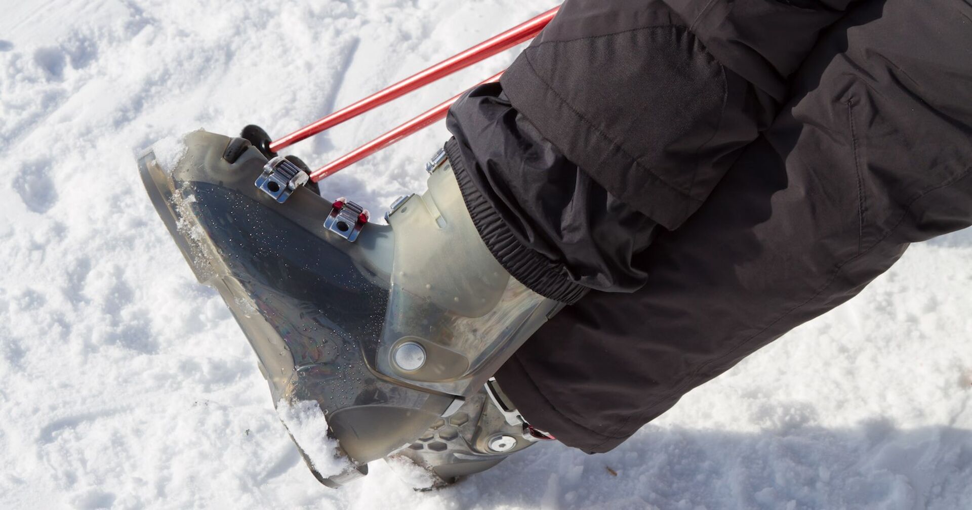 Schwarze Skihose und silberne Skischuhe.