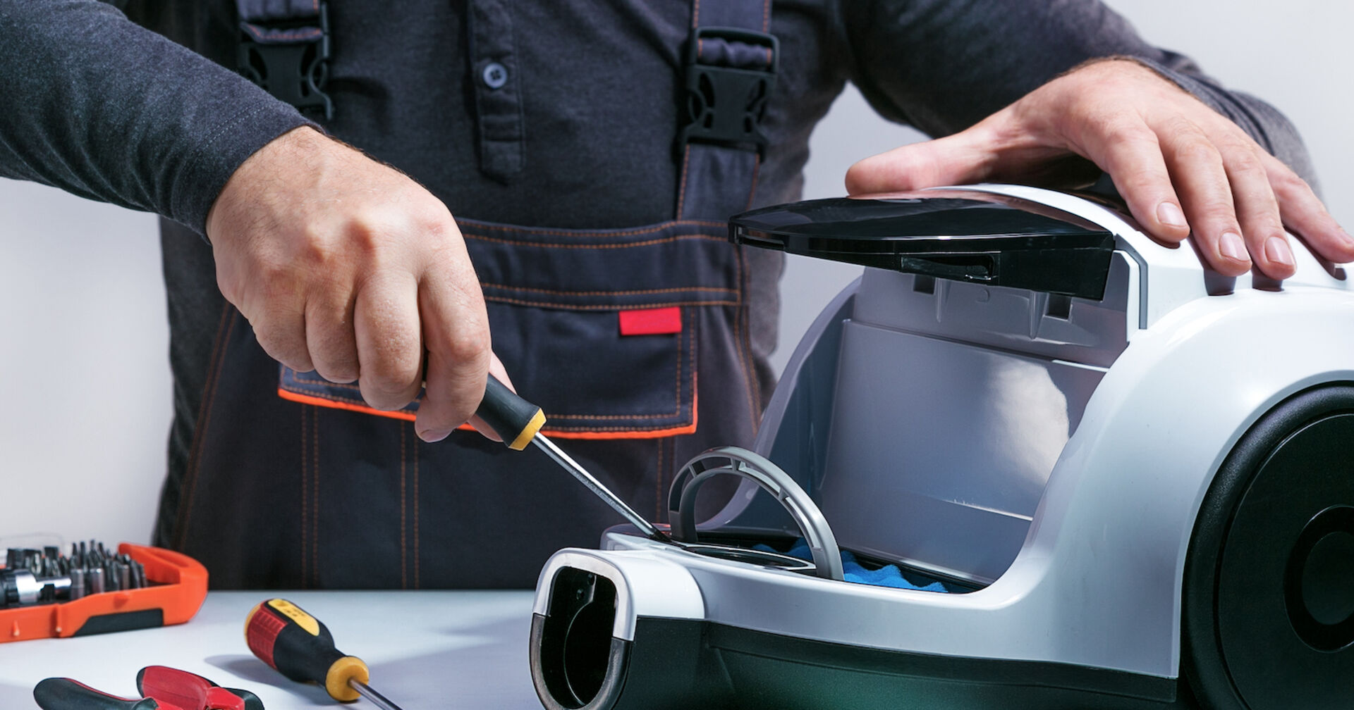 Handwerker repariert grauen Staubsauger | Credit: Sergei Chuyko/istock.com