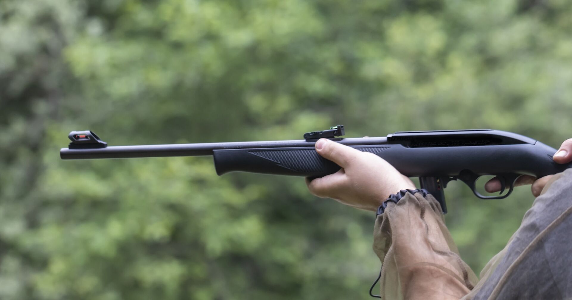 Ein Mann feuert aus einem Kleinkalibergewehr.