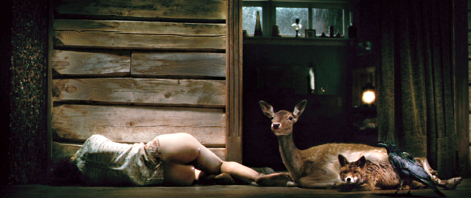 Eine Szenen aus dem Film "Antichrist": Eine Frau liegt nackt auf dem Boden einer Waldhütte, neben ihr ruhen ein Reh sowie ein Fuchs
