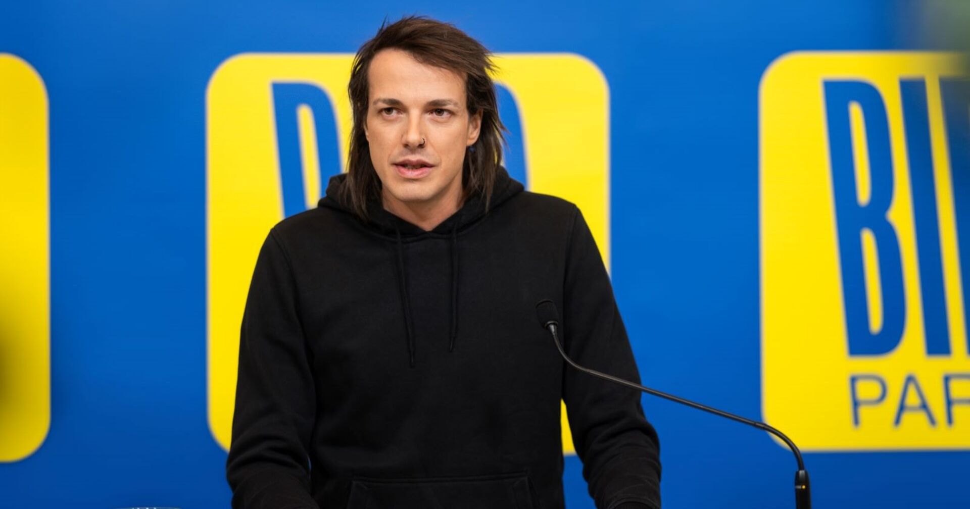 Bierpartei-Gründer Dominik Wlazny alias Marco Pogo vor der Pressewand der Bierpartei.