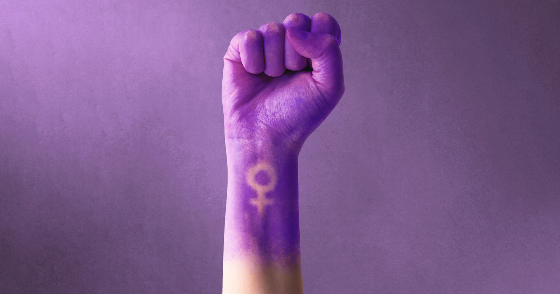 Internationaler Frauentag: Eine weibliche Hand in violett reckt die Faust mit dem Zeichen für Frauen.