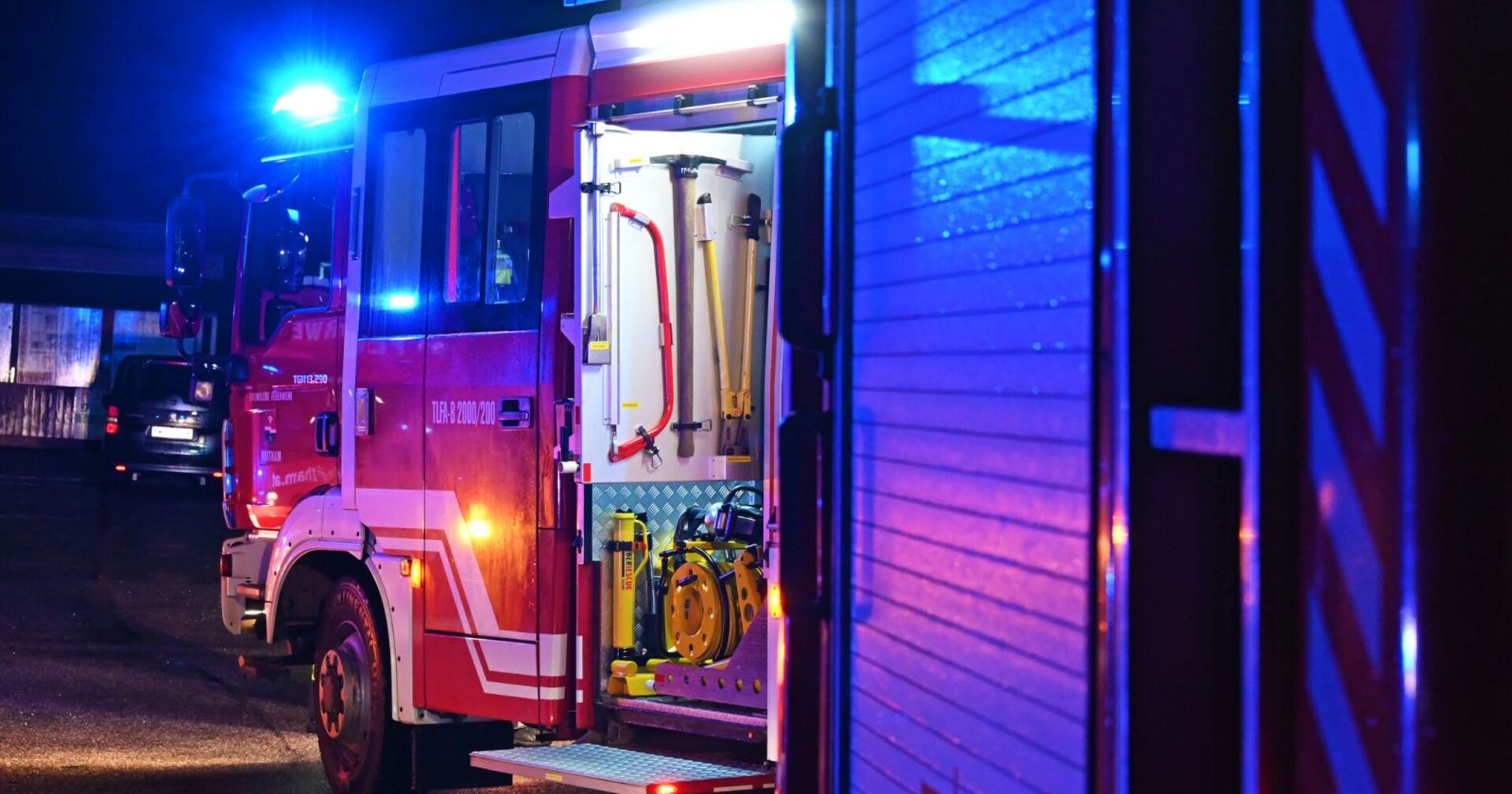 Eine Feuerwehrauto mit Blaulicht in der Nacht.