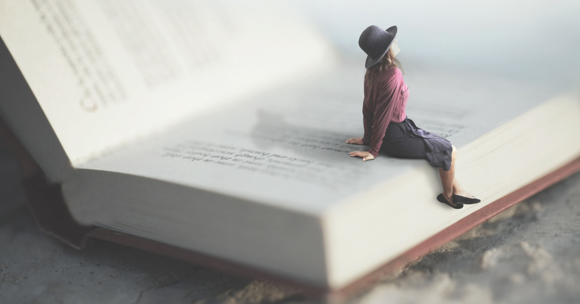 Eine Frau sitzt in einem überdimensionalen Buch