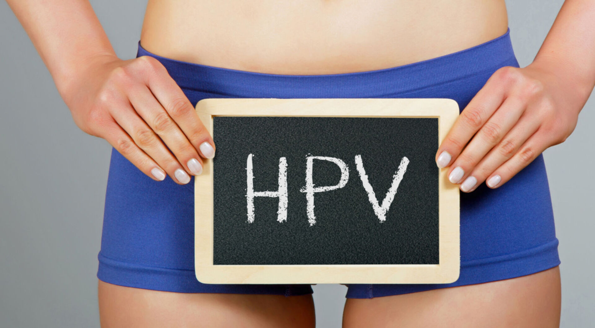 Frau hält Schild mit der Aufschrift "HPV"