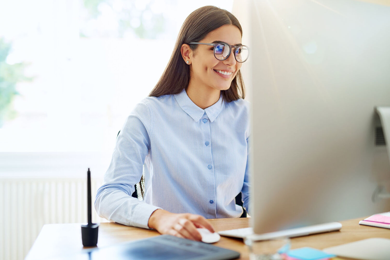 Frau arbeitet am Computer | Credit: iStock.com/FlamingoImages