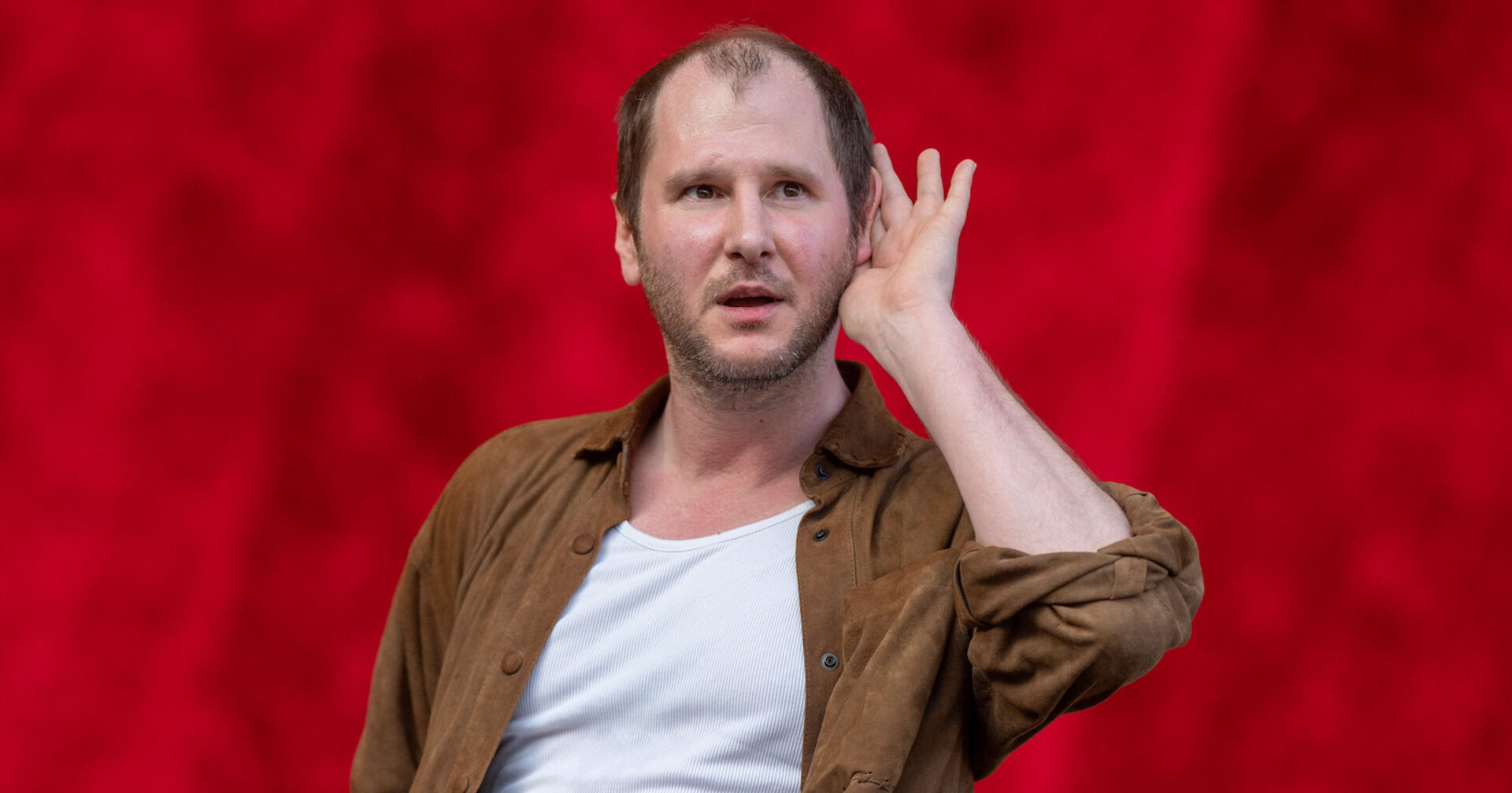 Marco Wanda auf der Bühne mit einem braunen Hemd und einem weißen T-Shirt.