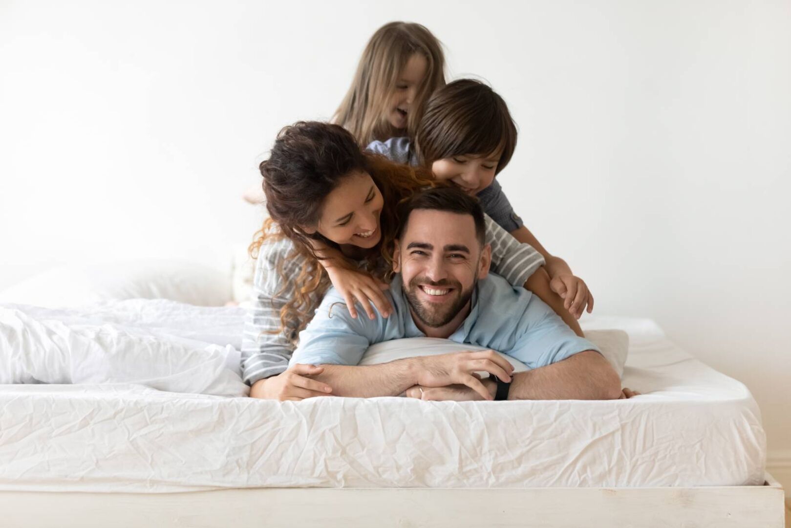 Familie, die gemeinsam am Bett kuschelt