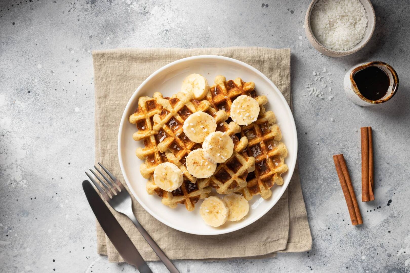 Teller mit gebackenen Waffeln, garniert mit Bananenscheiben