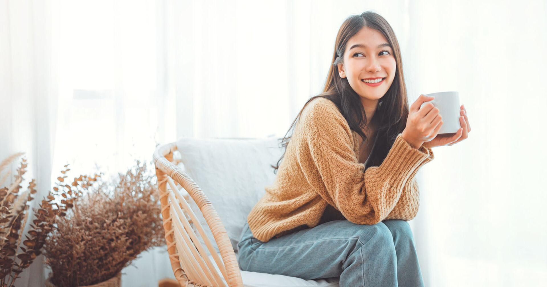 Frau sitzt glücklich in einem Stuhl | Credit: iStock.com/oatawa