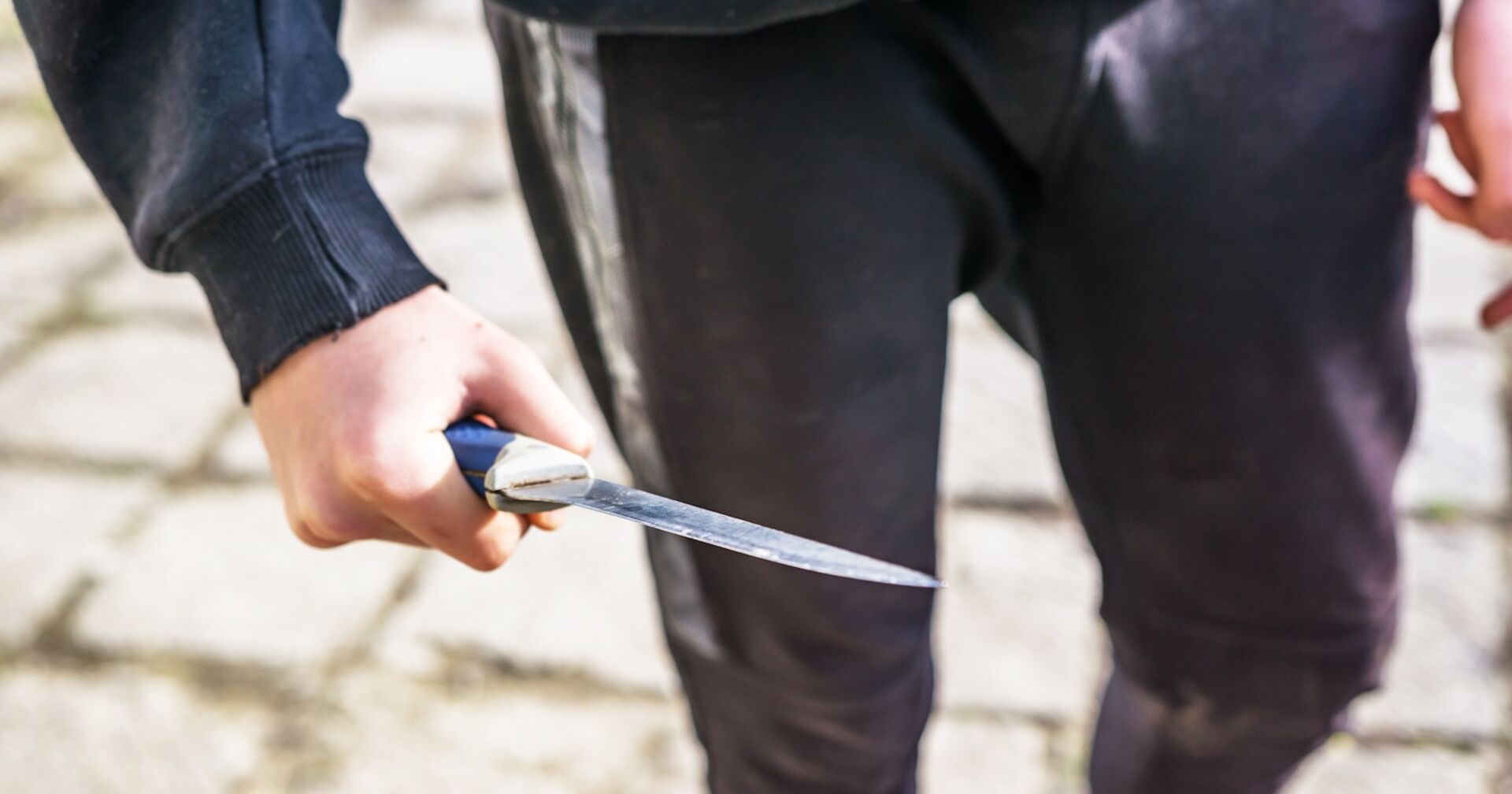 Ein junger Mann mit einem Messer auf der Straße.