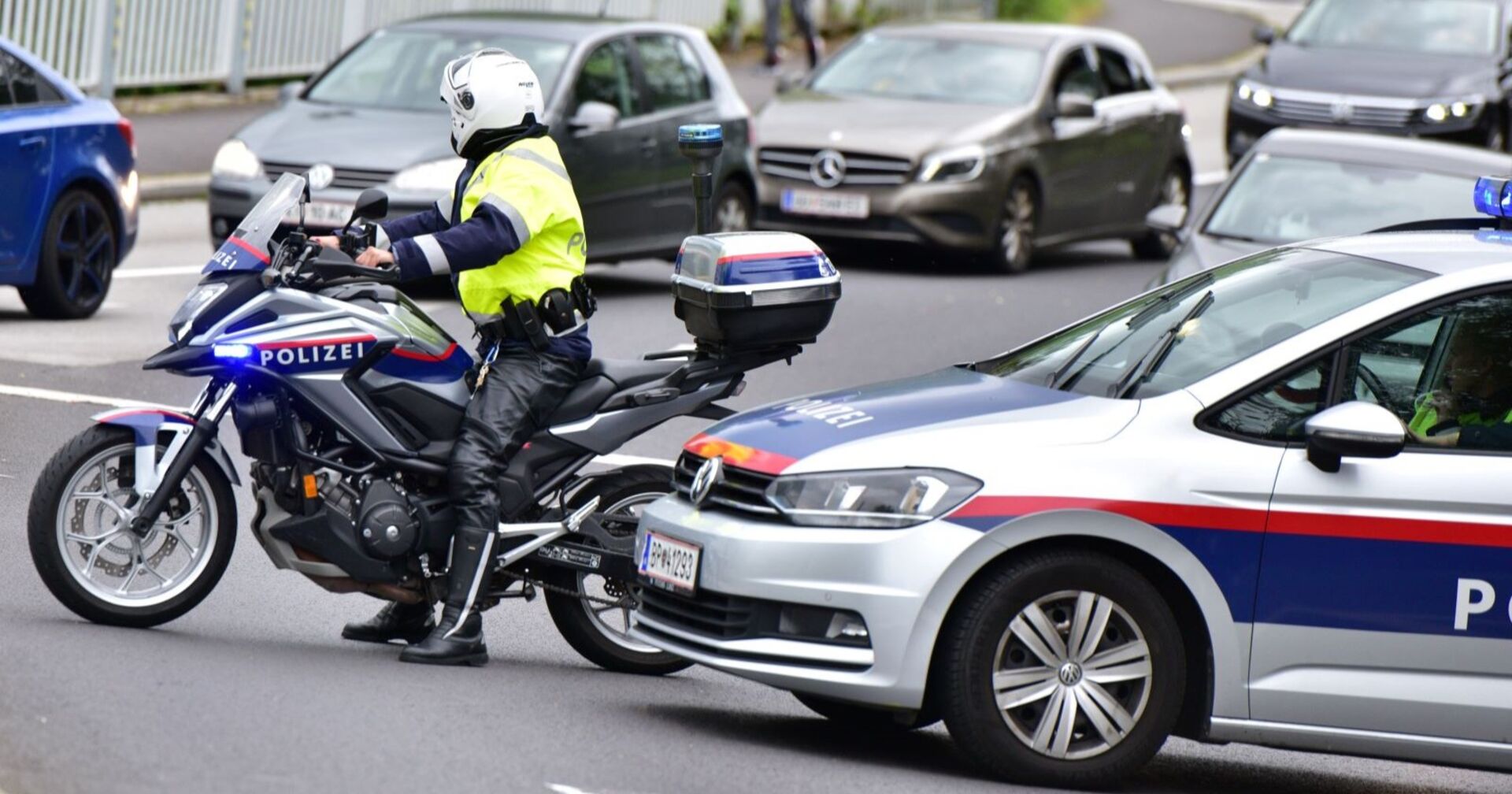 Ein Polizist auf einem Motorrad, ein Polizeiauto