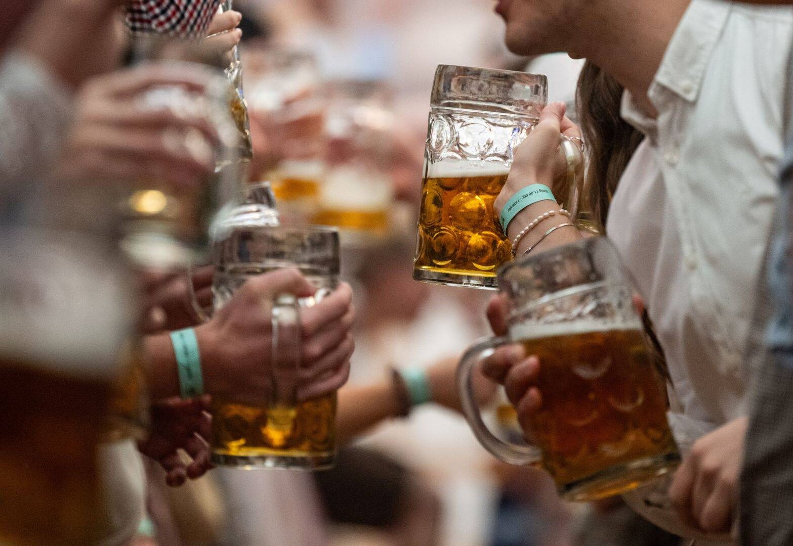 Freunde prosten sich mit eine Bierkrug zu.