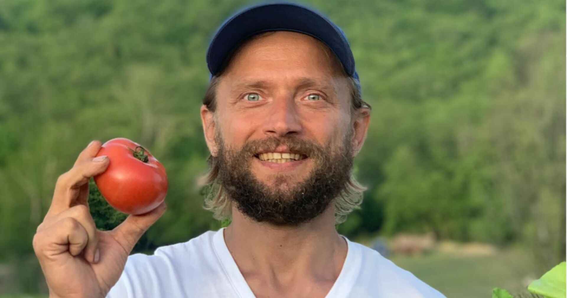 "Influencer" Maxim Lyutyi lächelnd und mit einer Tomate in der Hand.