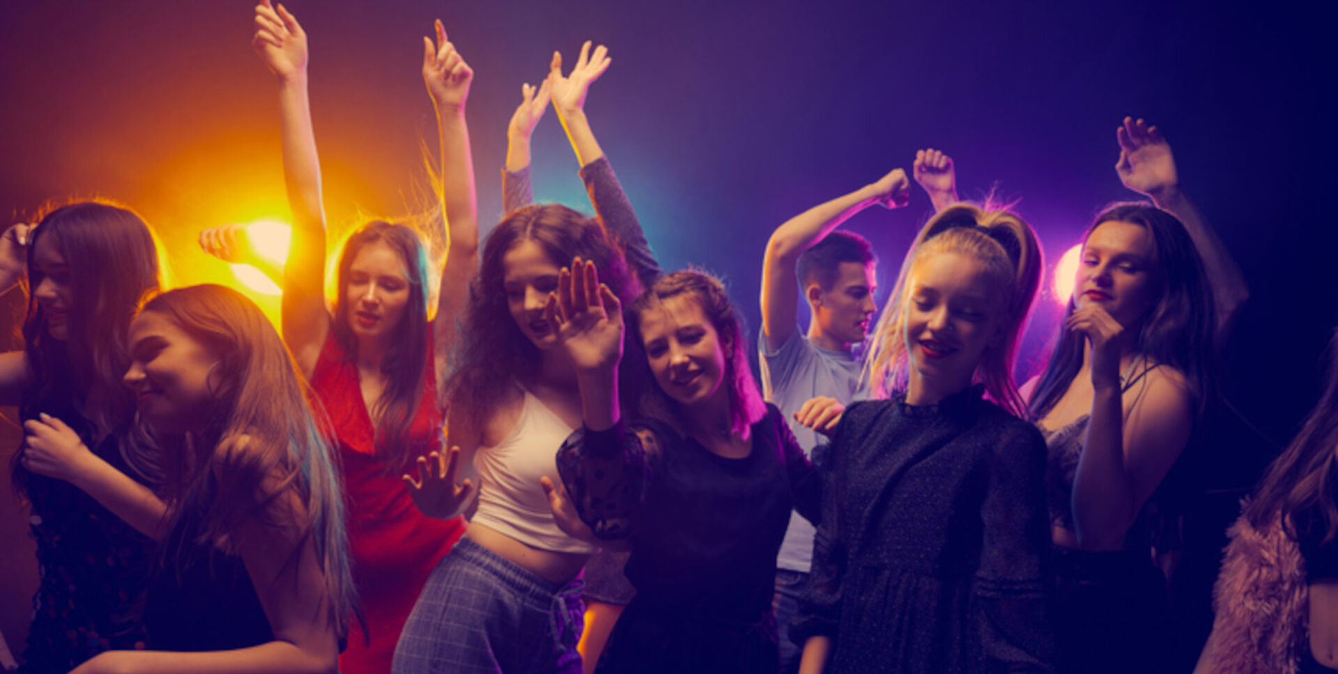 Mehrere junge Menschen tanzen in einem Club