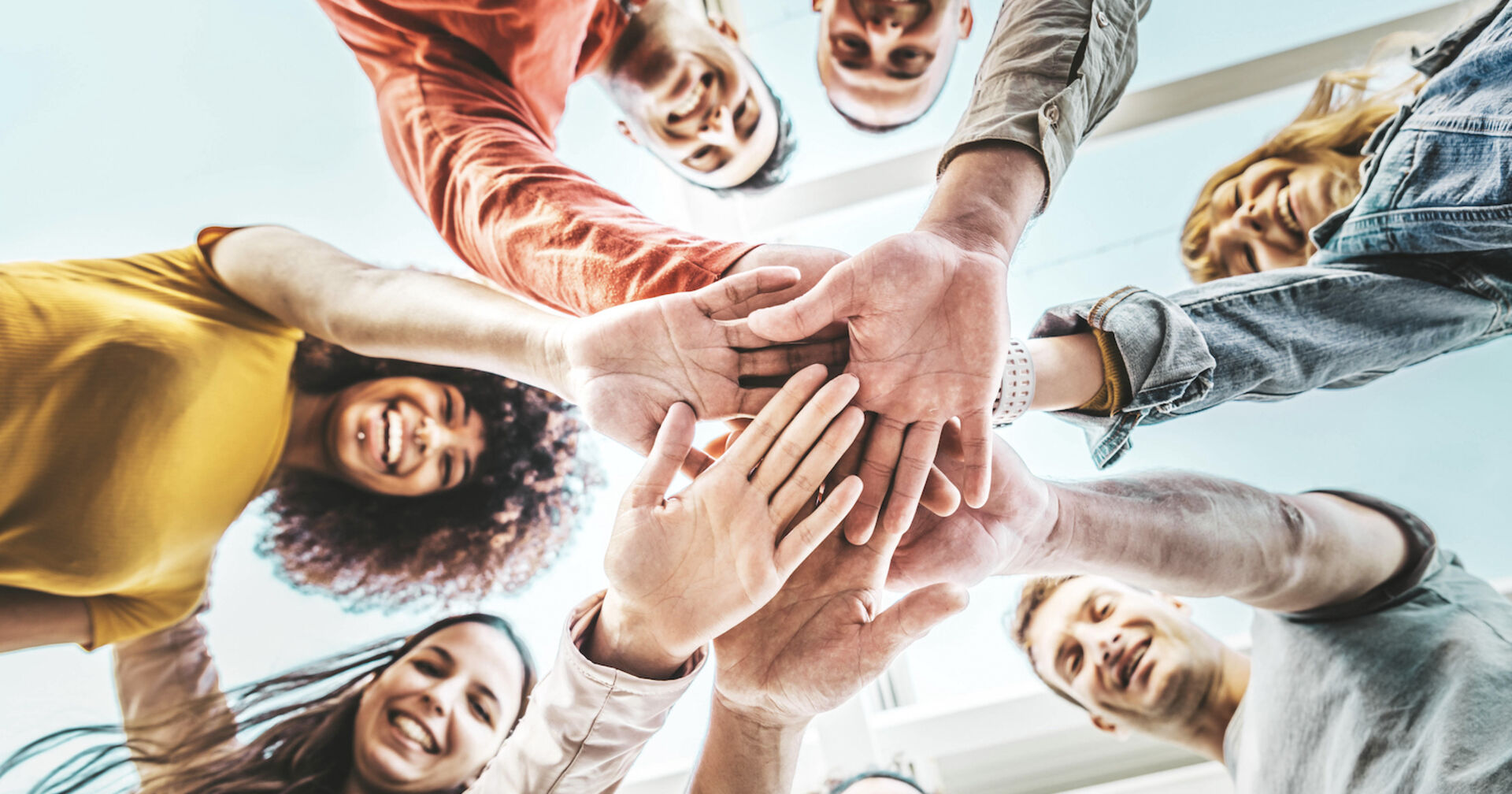 junge Menschen legen ihre Hände aufeinander