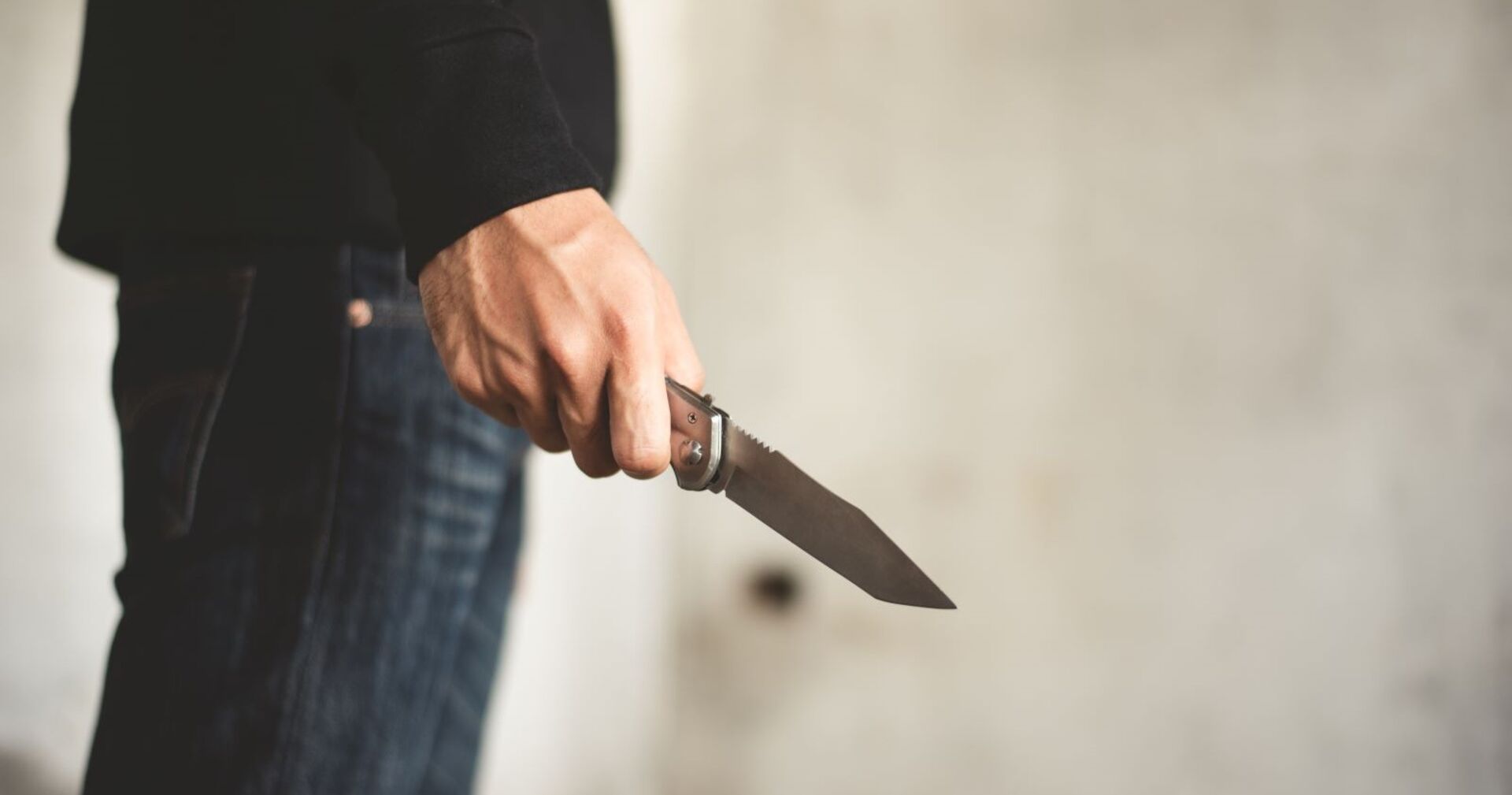 Ein Mann mit einem Messer in einem Stiegenhaus.