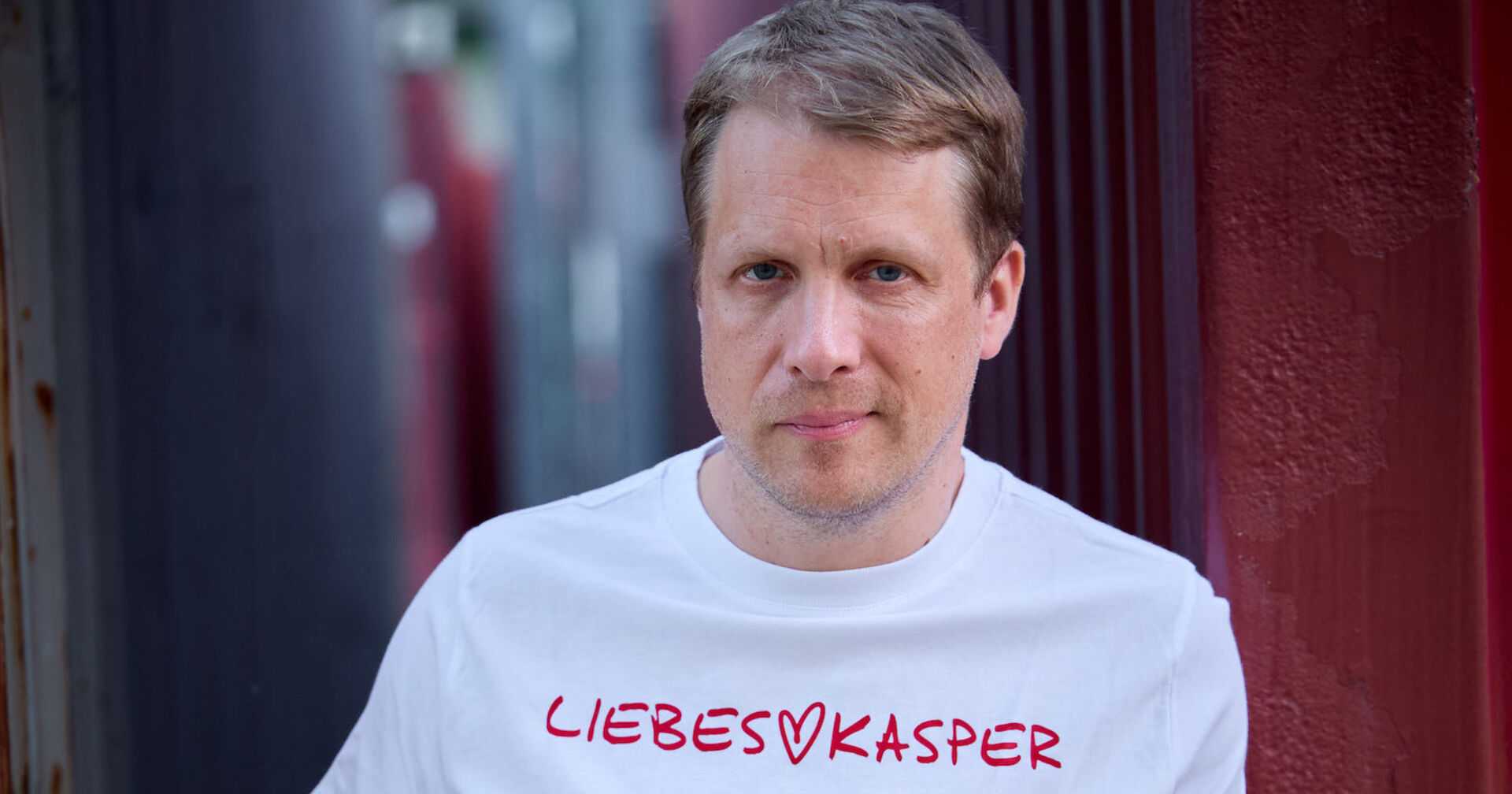 Oliver Pocher mit einem weißen T-Shirt auf dem steht: Liebeskasper.