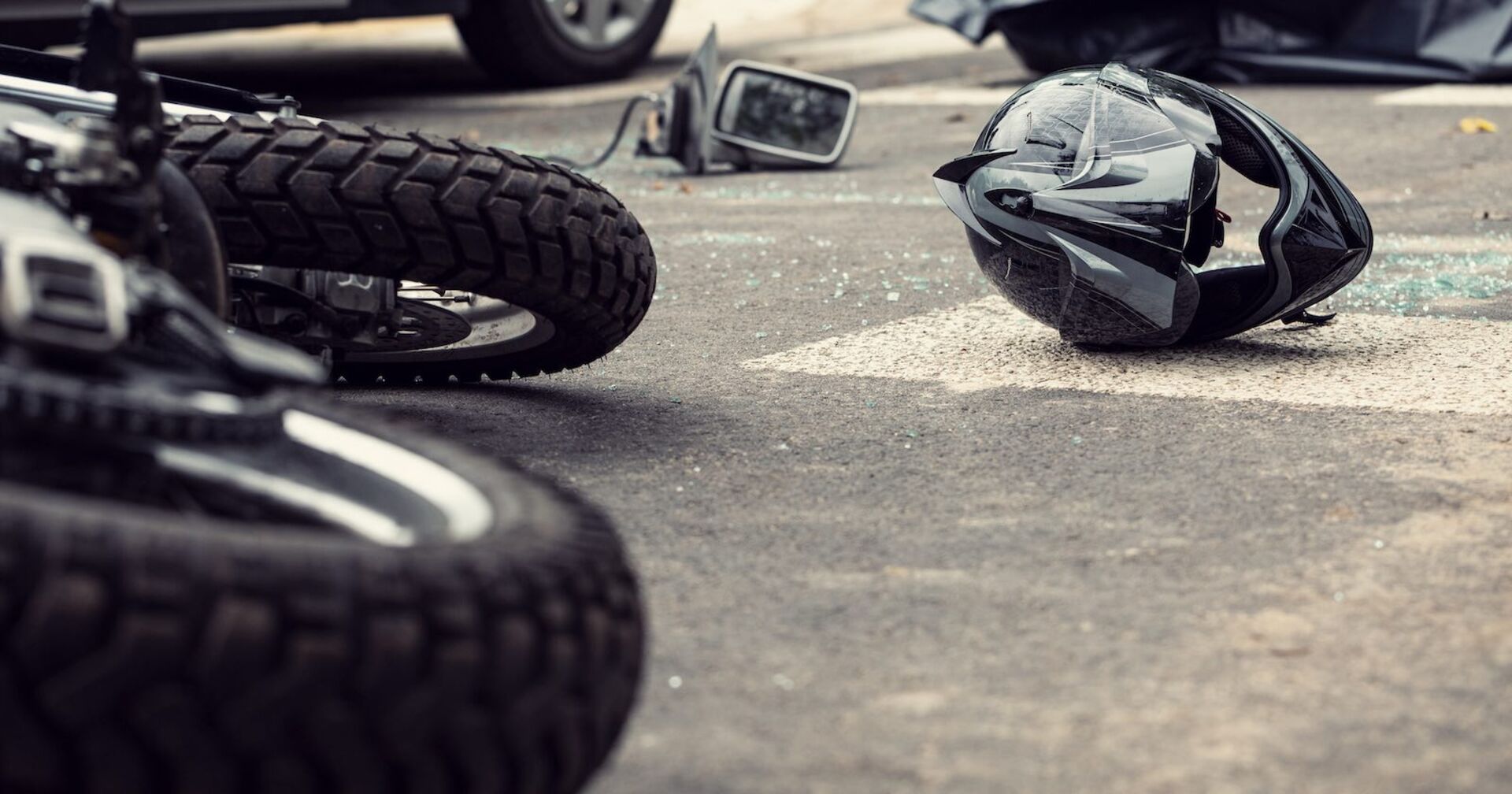 Ein Motorrad und ein Helm liegen nach einem Unfall auf der Straße.