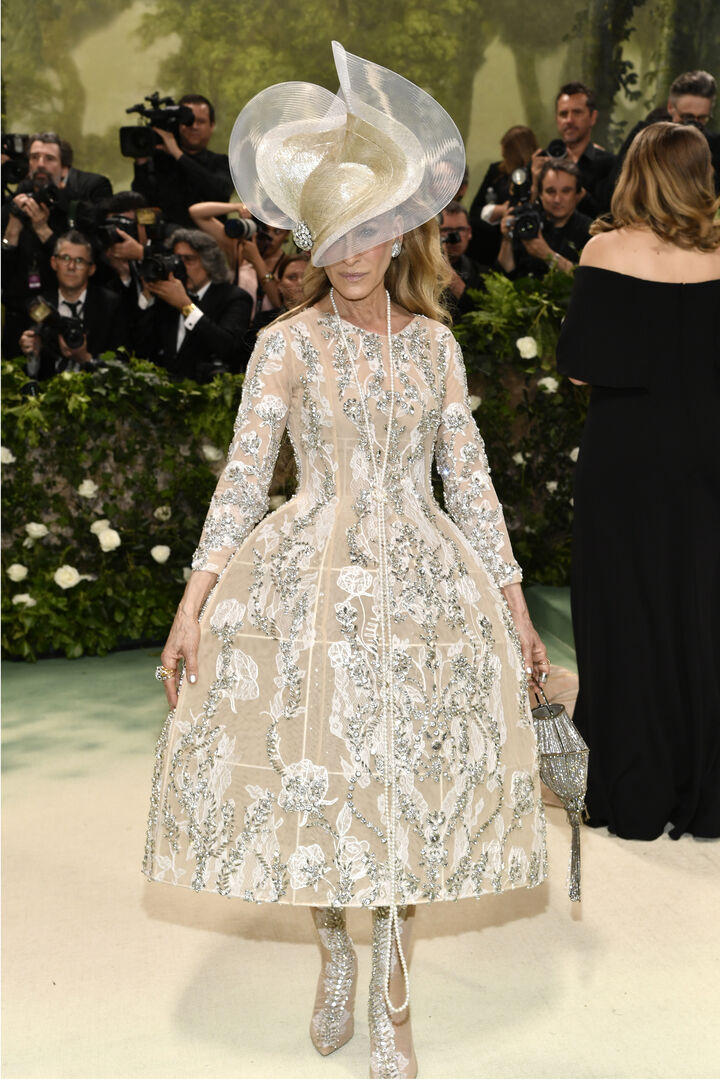 Eine Frau in einem Glitzerkleid mit riesigem Hut