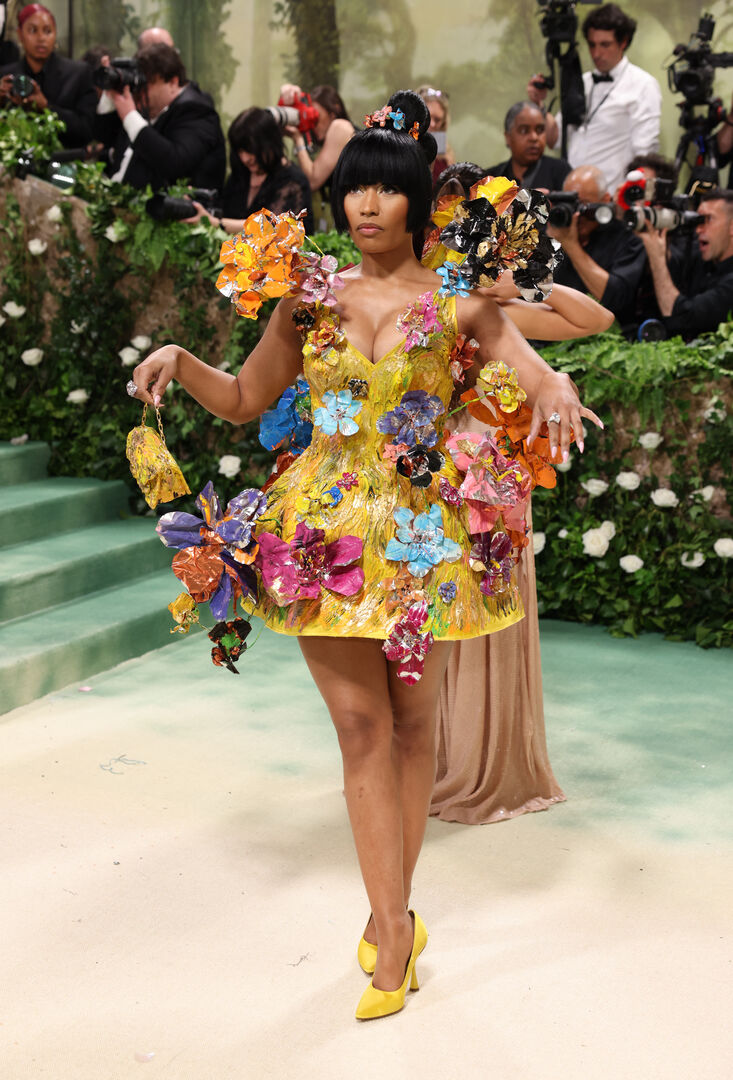 eine Frau in einem gelben kurzen Kleid mit Blumen-Applikationen